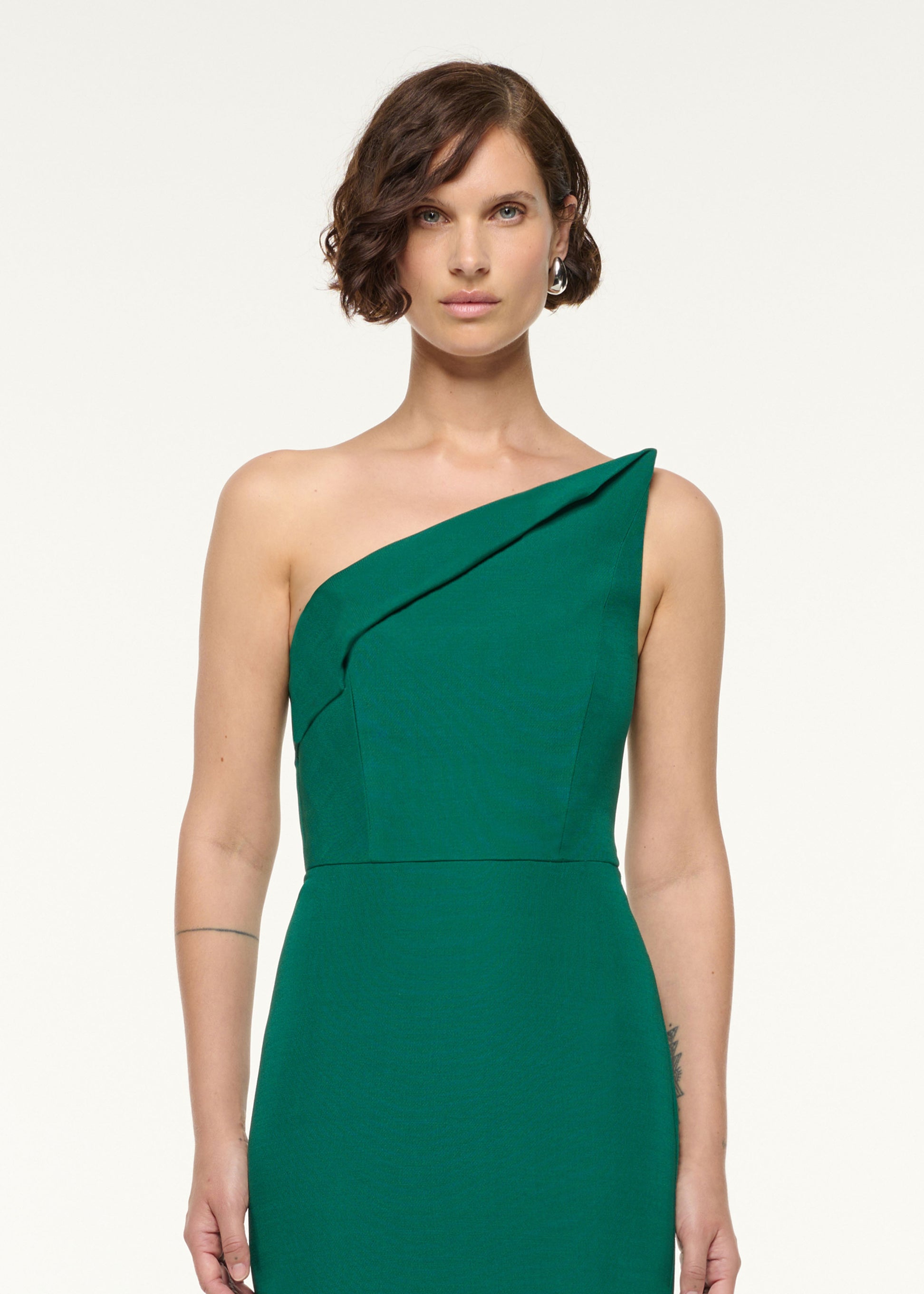 Close up of a model wearing the Asymmetrical Fold Wool Silk Gown in Green