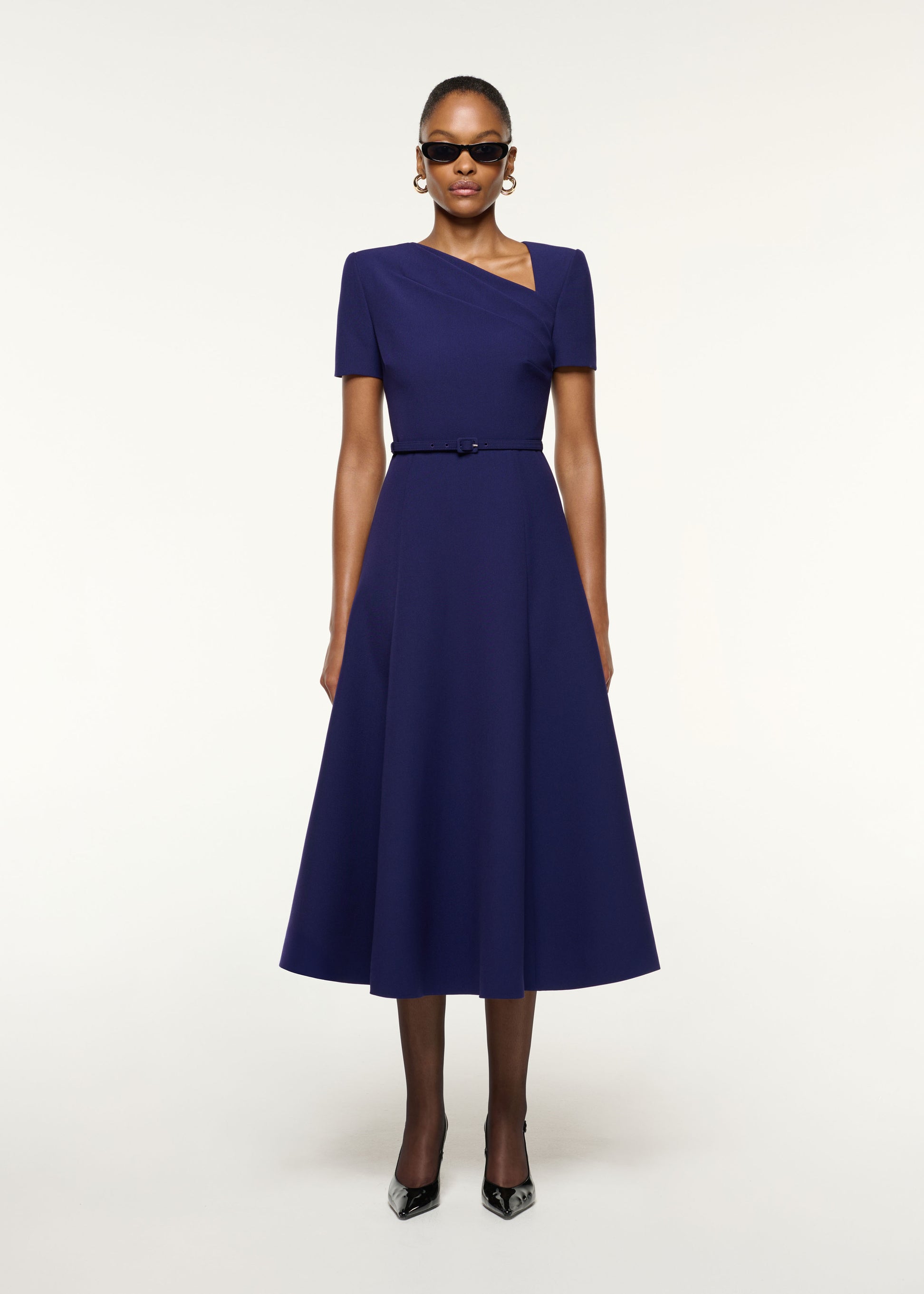 Front view of a model wearing the Asymmetrical Neckline Crepe Midi Dress in Navy