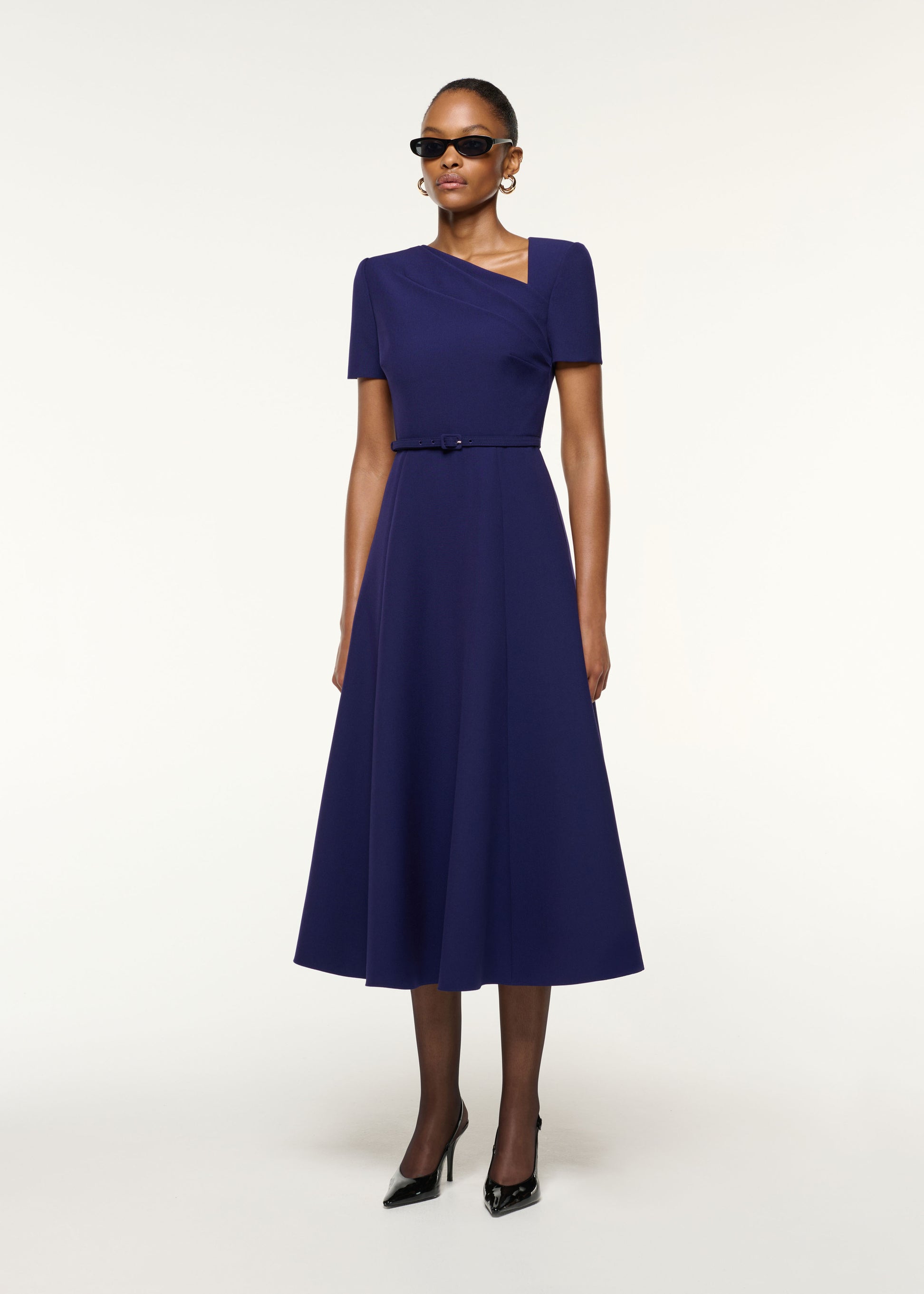 Side view of a model wearing the Asymmetrical Neckline Crepe Midi Dress in Navy
