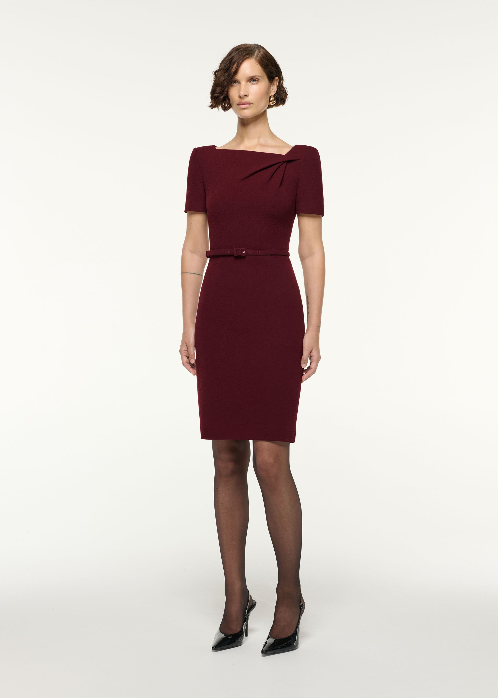 Side view of a model wearing the Asymmetrical Twist Belted Wool Dress in Mulberry