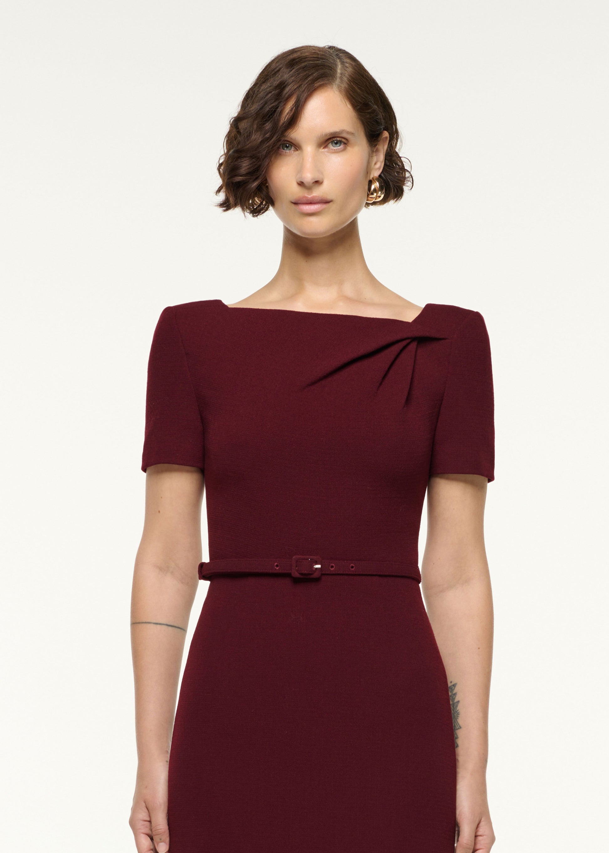 Close up of a model wearing the Asymmetrical Twist Belted Wool Dress in Mulberry