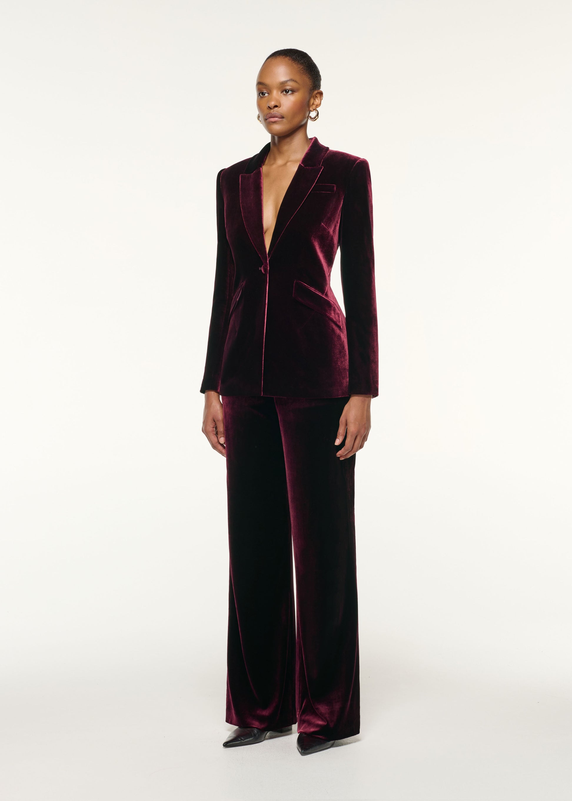 Side view of a model wearing the Tailored Velvet Jacket in Mulberry