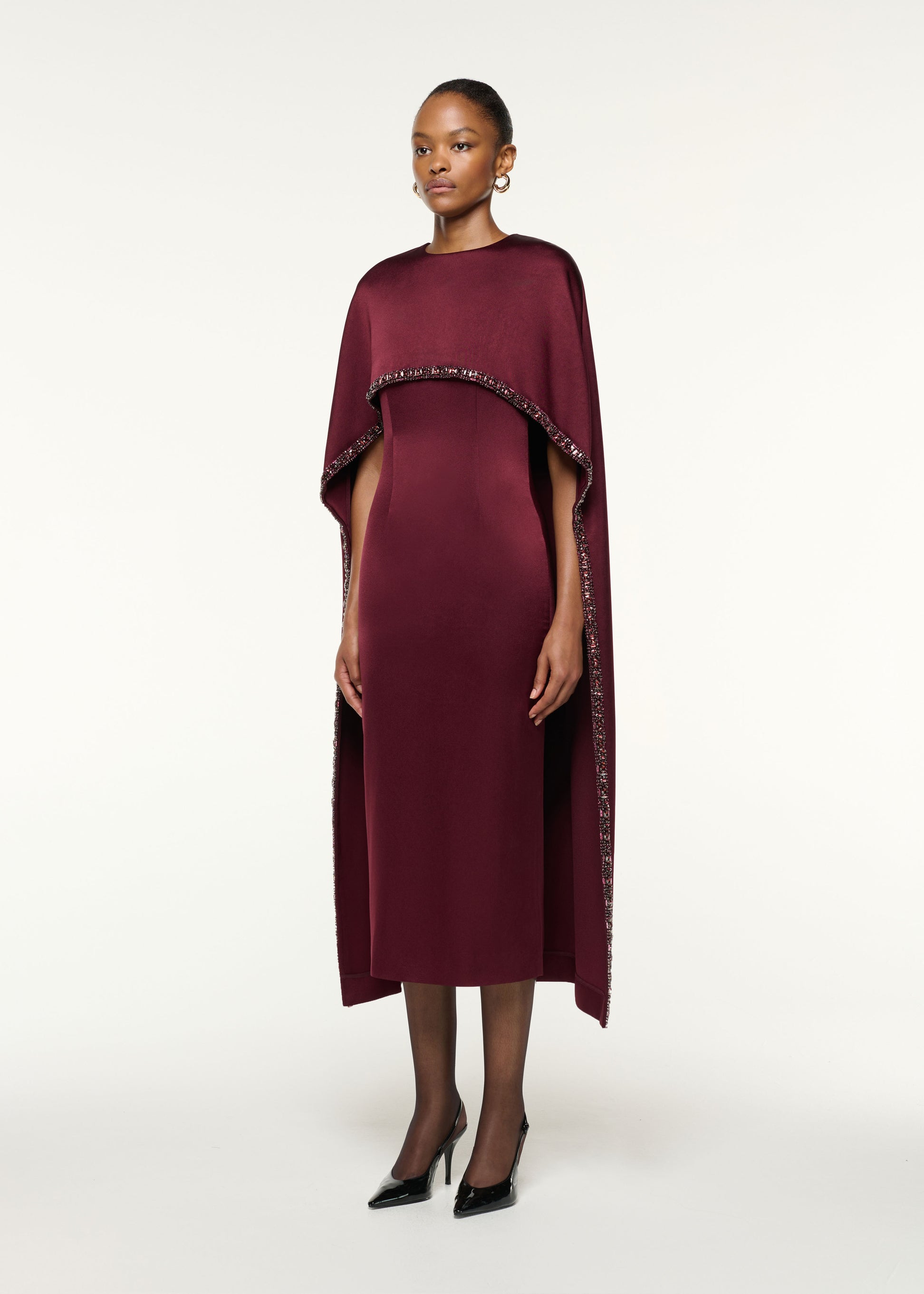 Side view of a model wearing the Crystal Trimmed Cape Midi Dress in Mulberry
