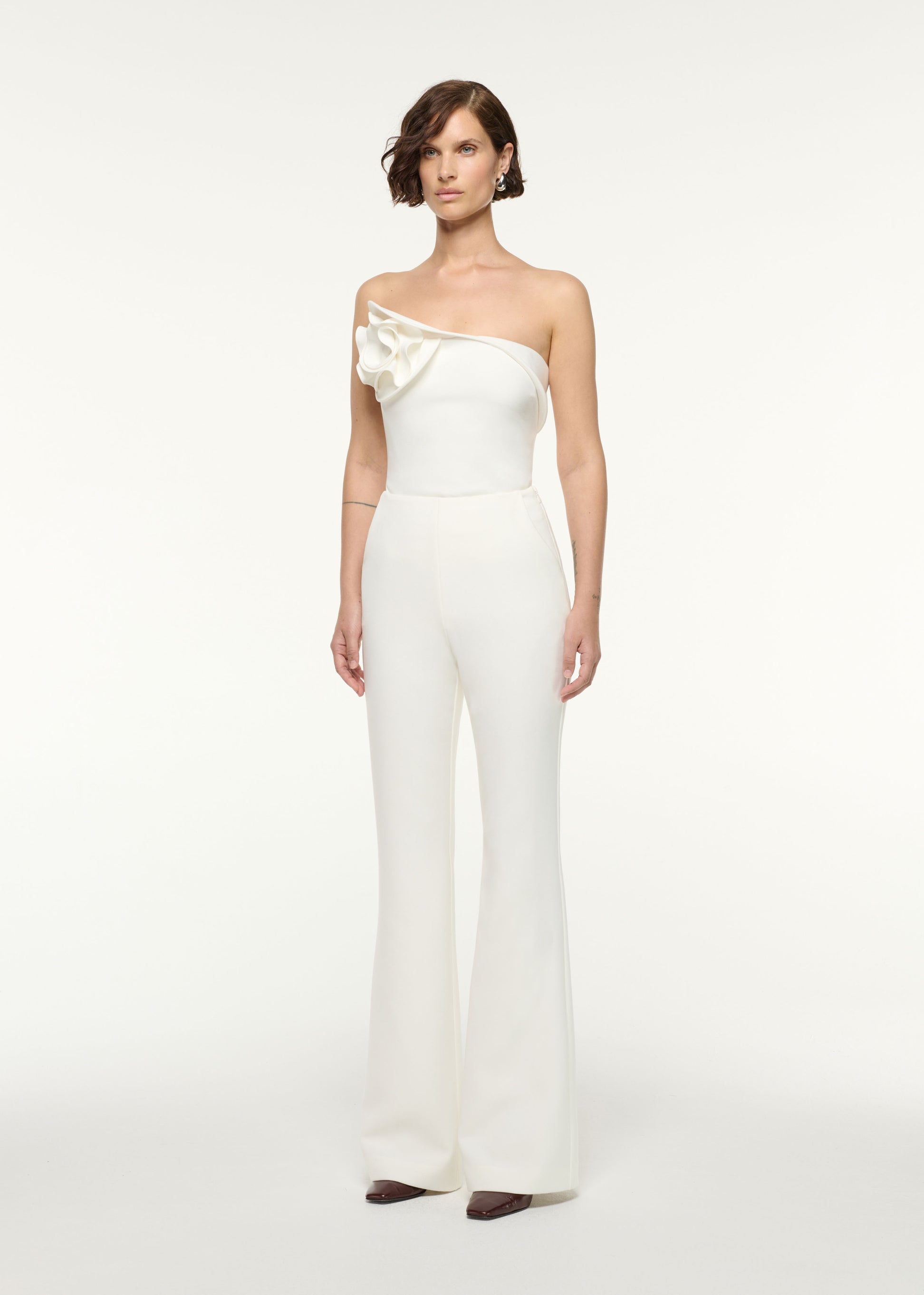 Side view of a model wearing the Tailored Fit And Flare Crepe Trouser in White