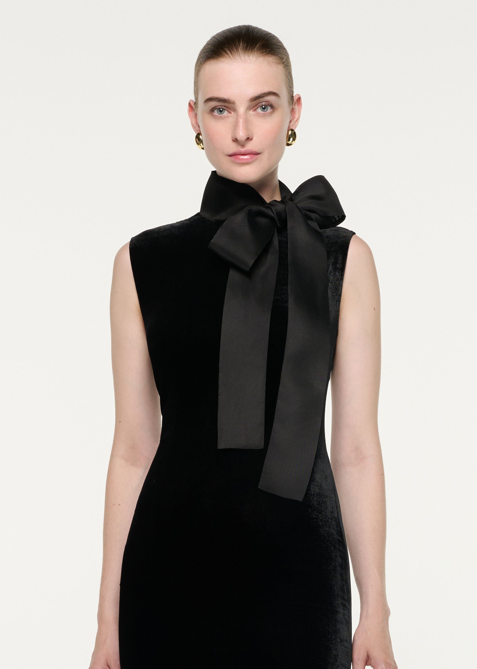 Close up of a model wearing the Velvet Midi Dress With Organza Bow Neck Tie