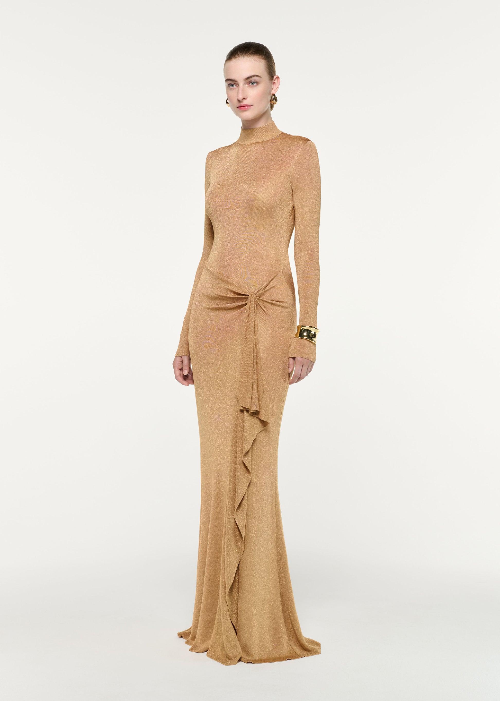 Side view of a model wearing the Lurex Knit Drape Long Sleeve Gown