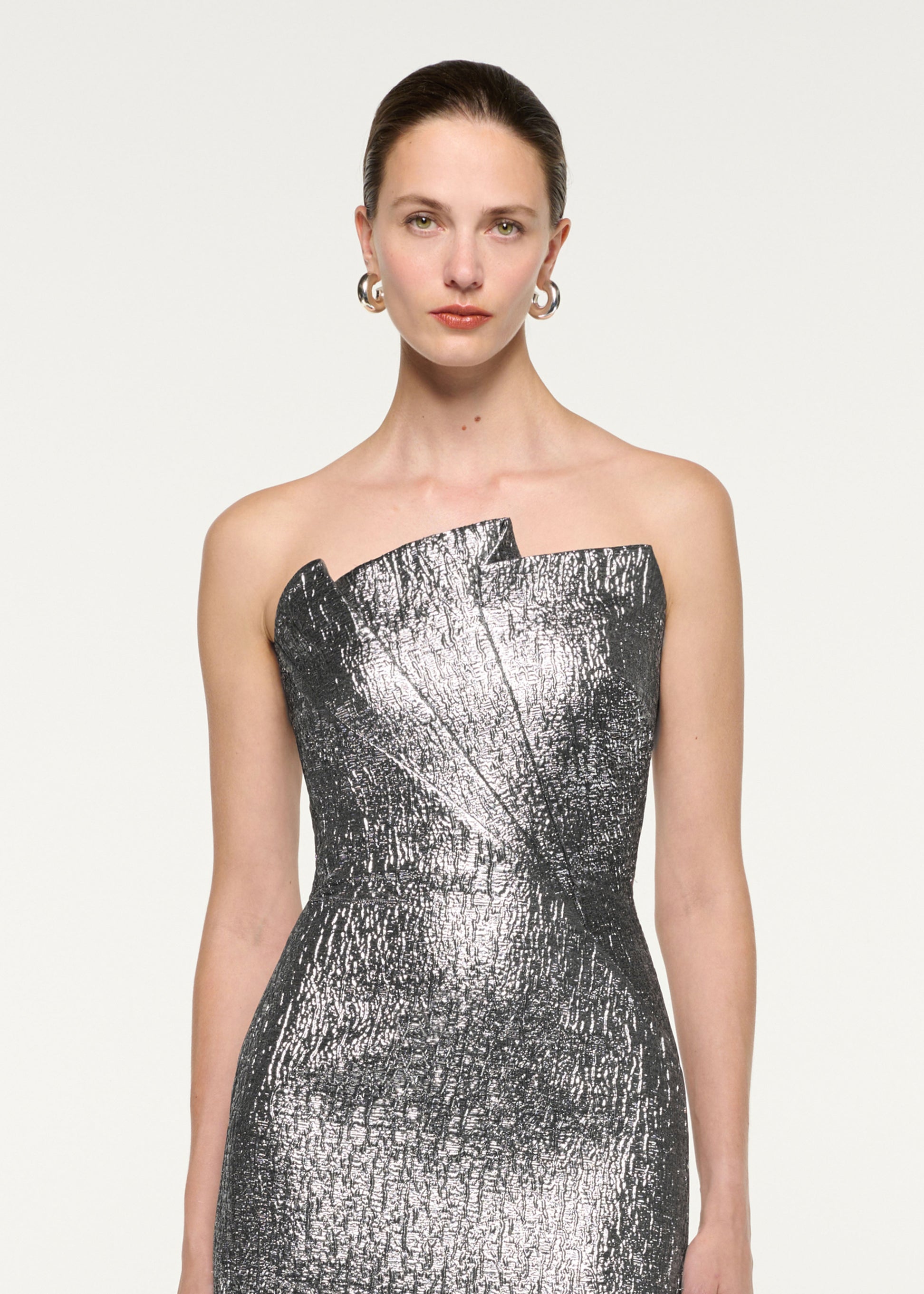 Close up of a model wearing the Pleated Strapless Metallic Jacquard Gown