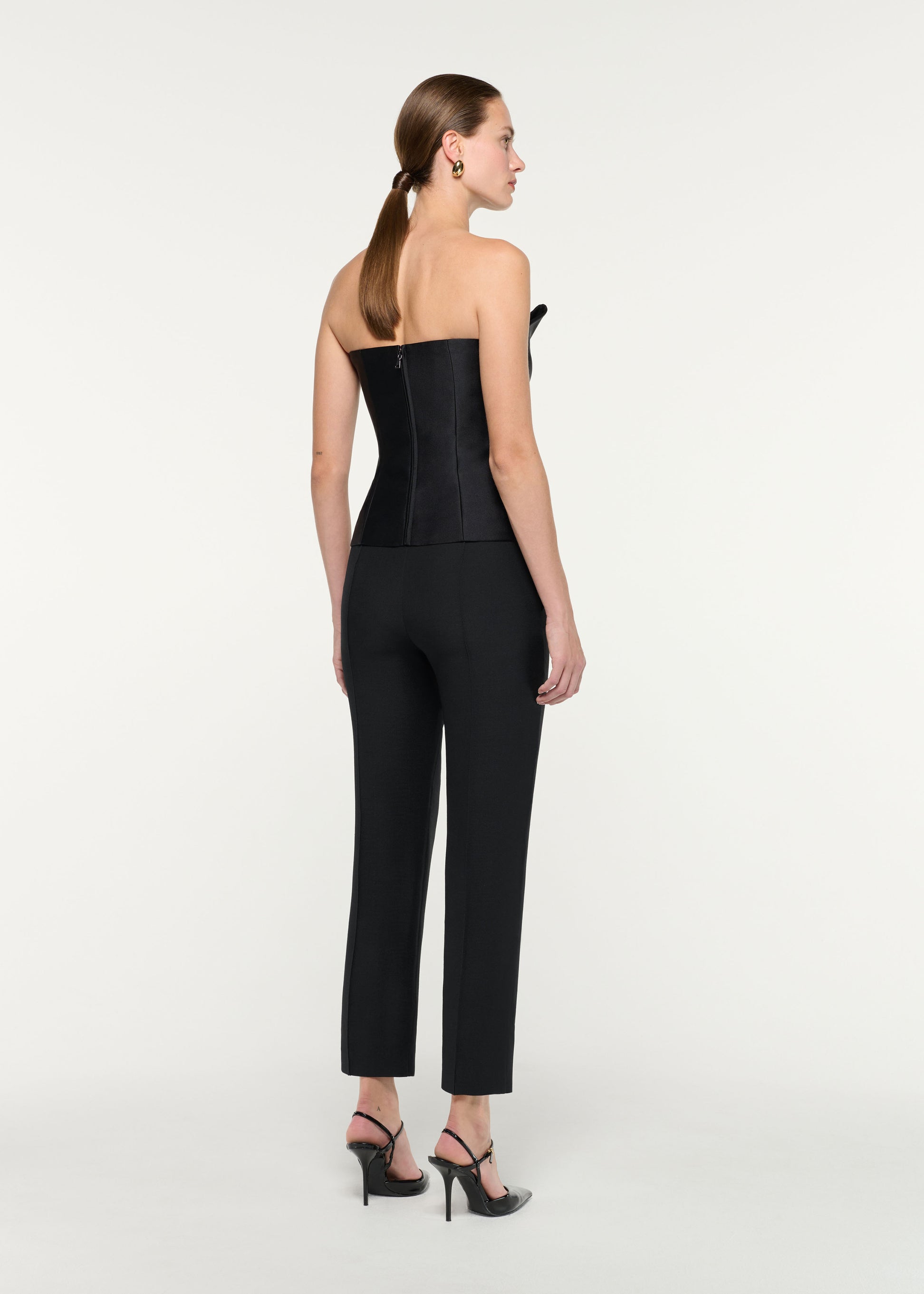 Back view of a model wearing the Pleated Strapless Taffeta Top