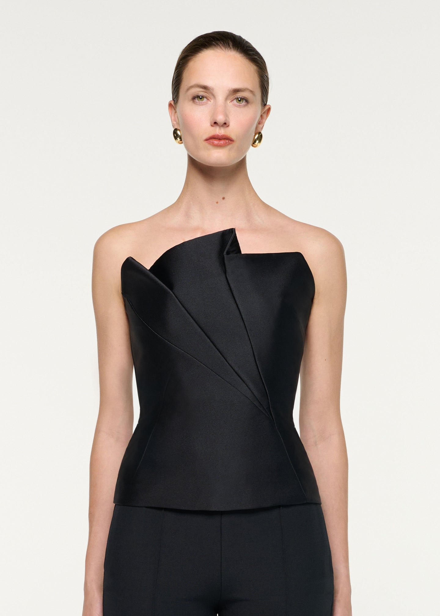Close up of a model wearing the Pleated Strapless Taffeta Top