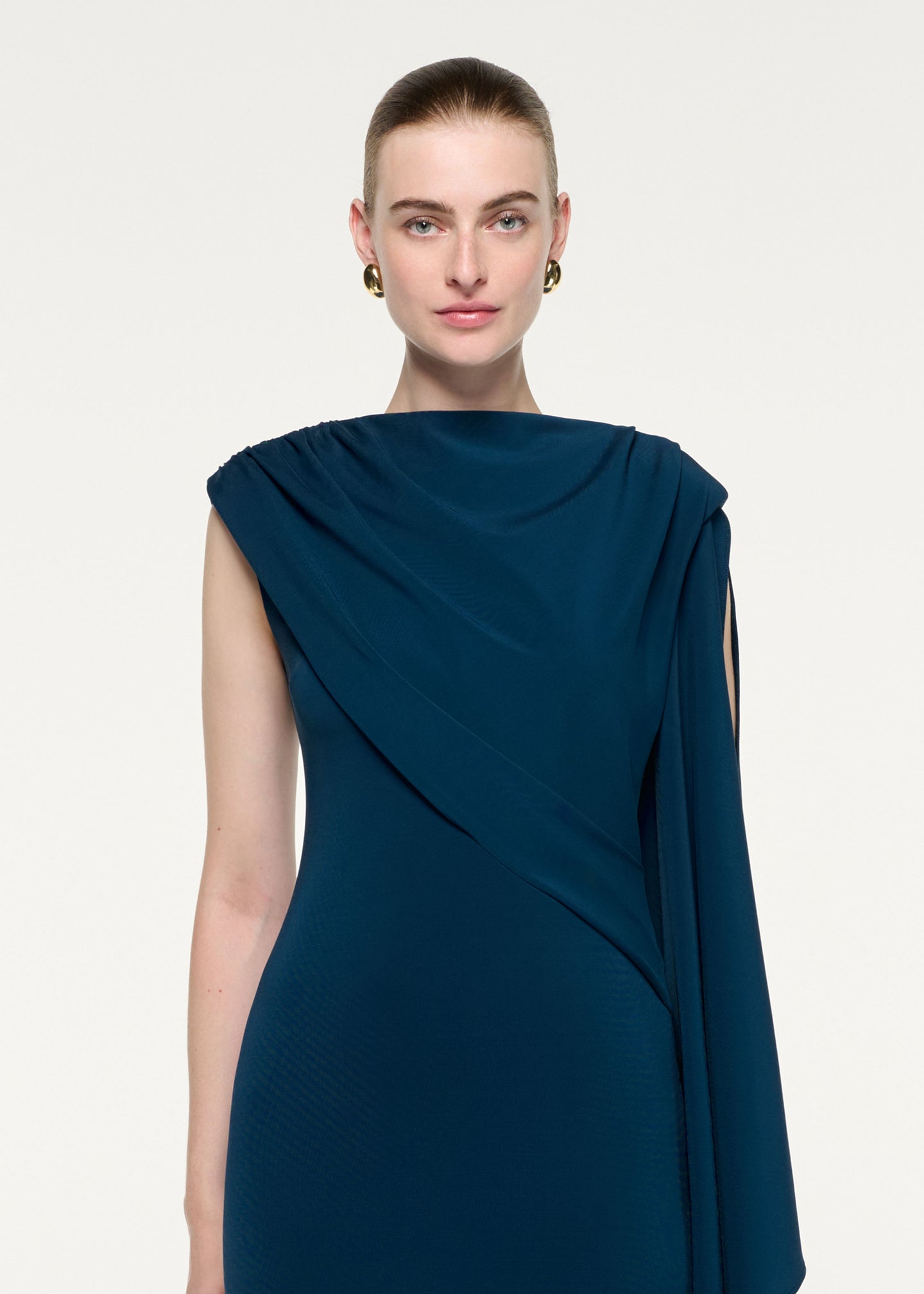 Close up of a model wearing the Asymmetric Cape Jersey Midi Dress