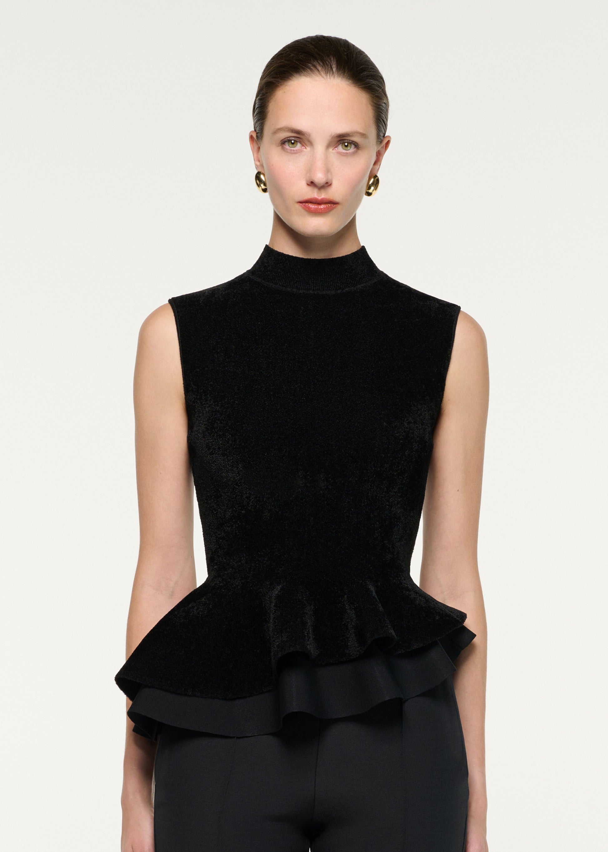 Close up of a model wearing the Sleeveless Chenille Knit Peplum Top