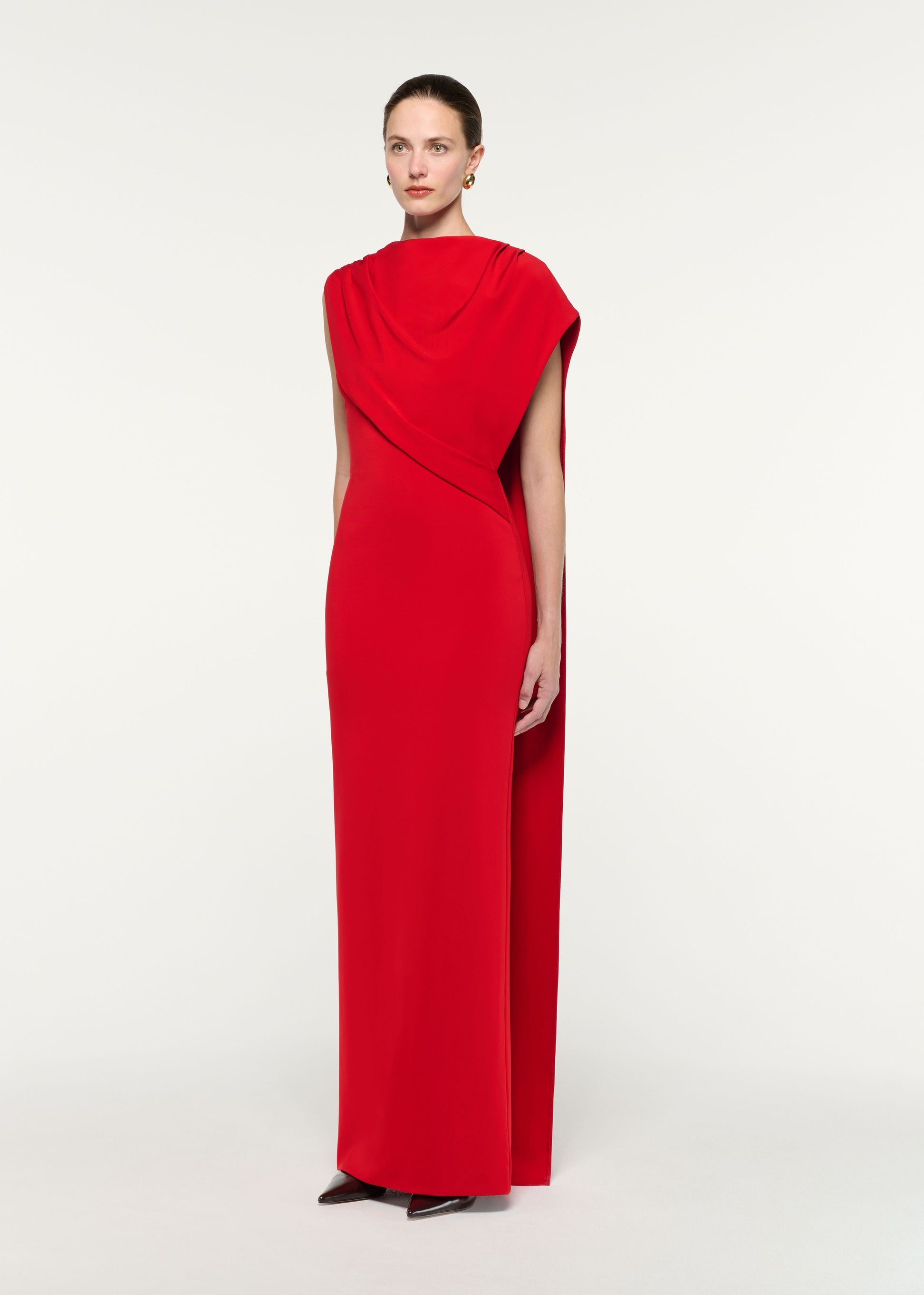 Side view of a model wearing the Asymmetric Cape Gown