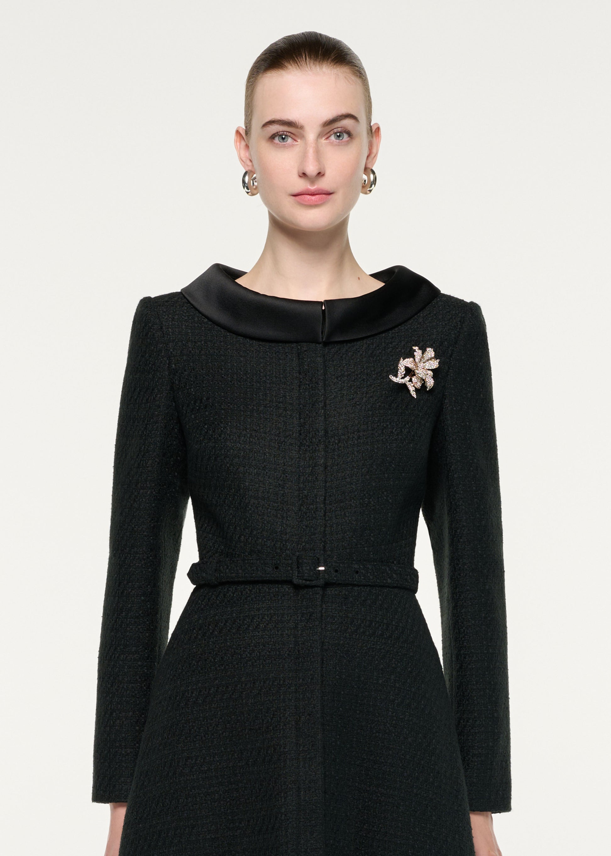 Close up of a model wearing the Boucle Coat With Flower Brooch