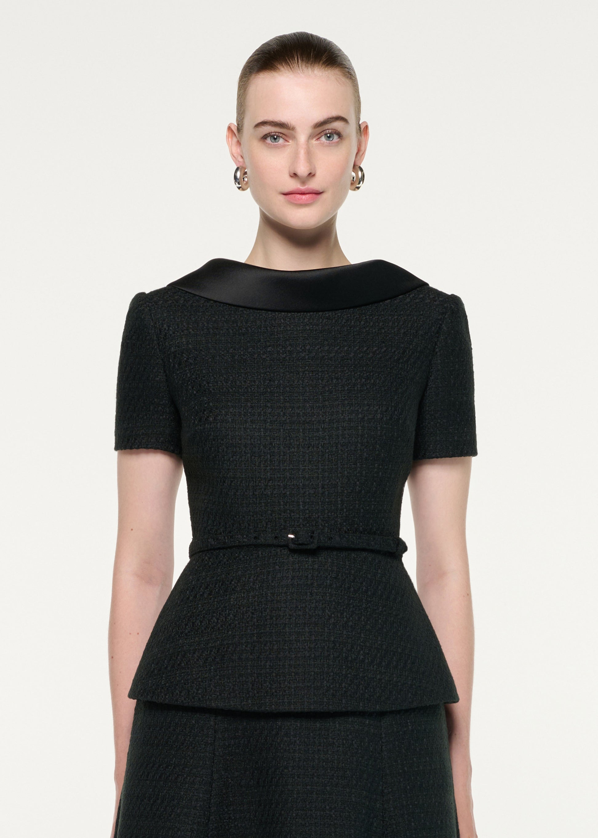 Close up of a model wearing the Collared Boucle Peplum Midi Dress