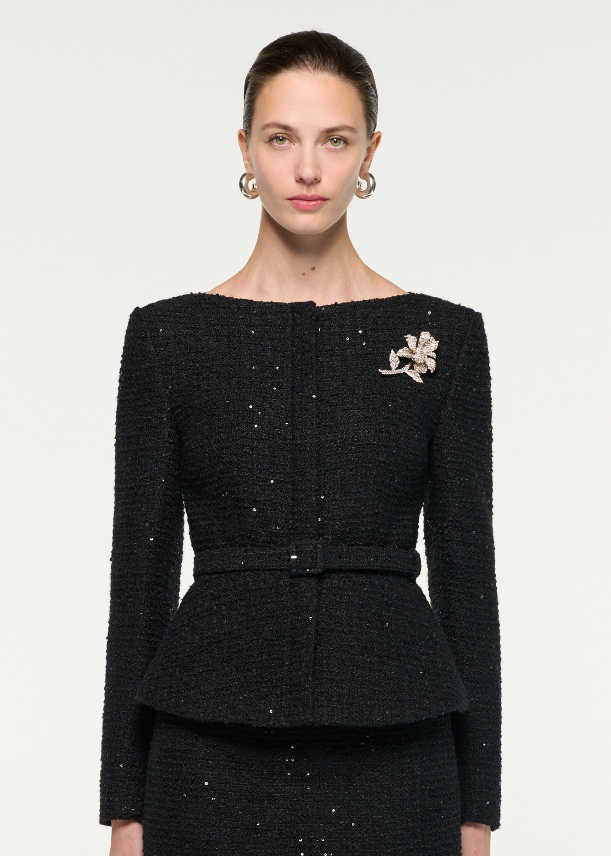 Close up of a model wearing the Flower Brooch Sequin Boucle Jacket
