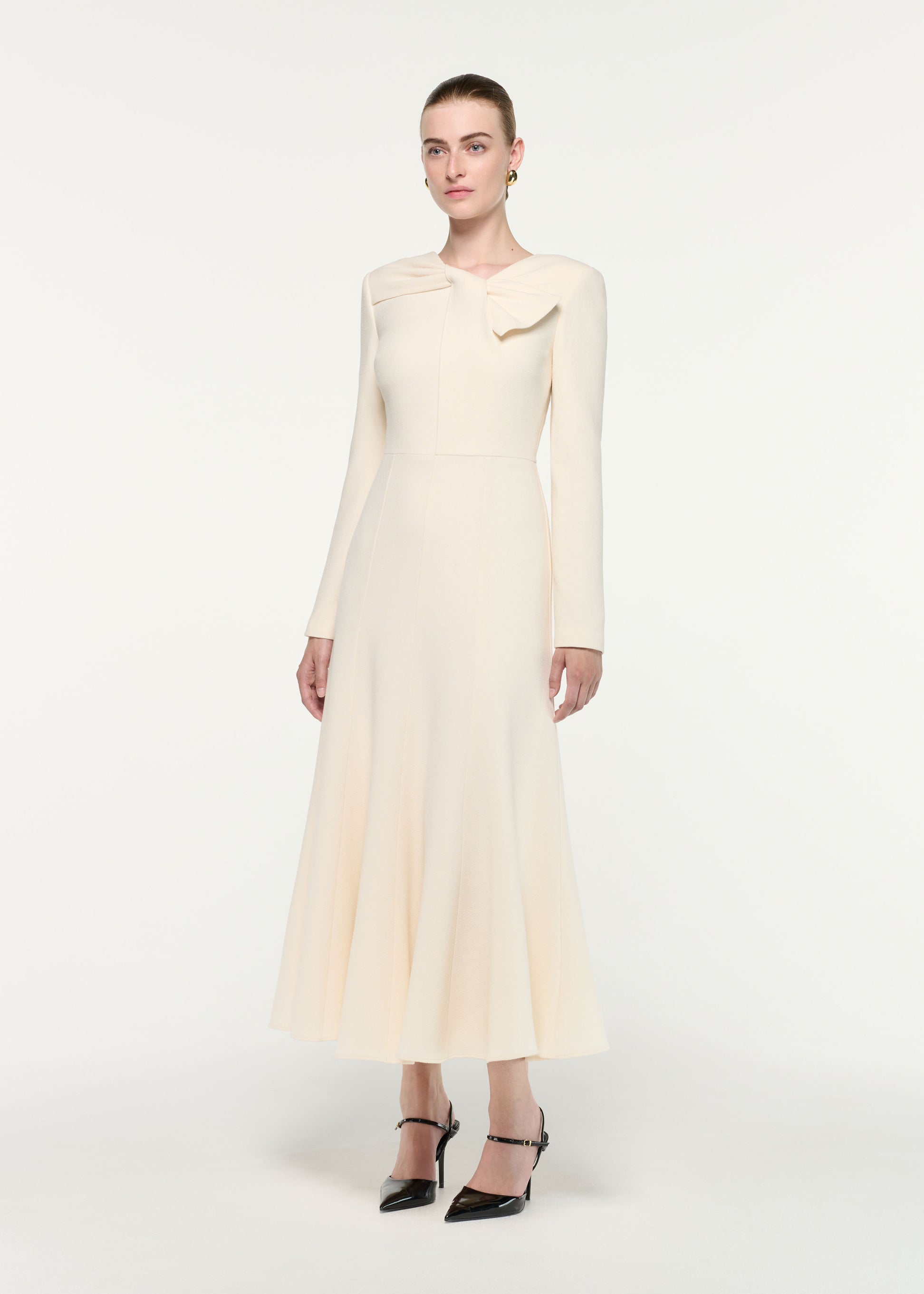 Side view of a model wearing the Asymmetric Bow Neck Wool Crepe Midi Dress
