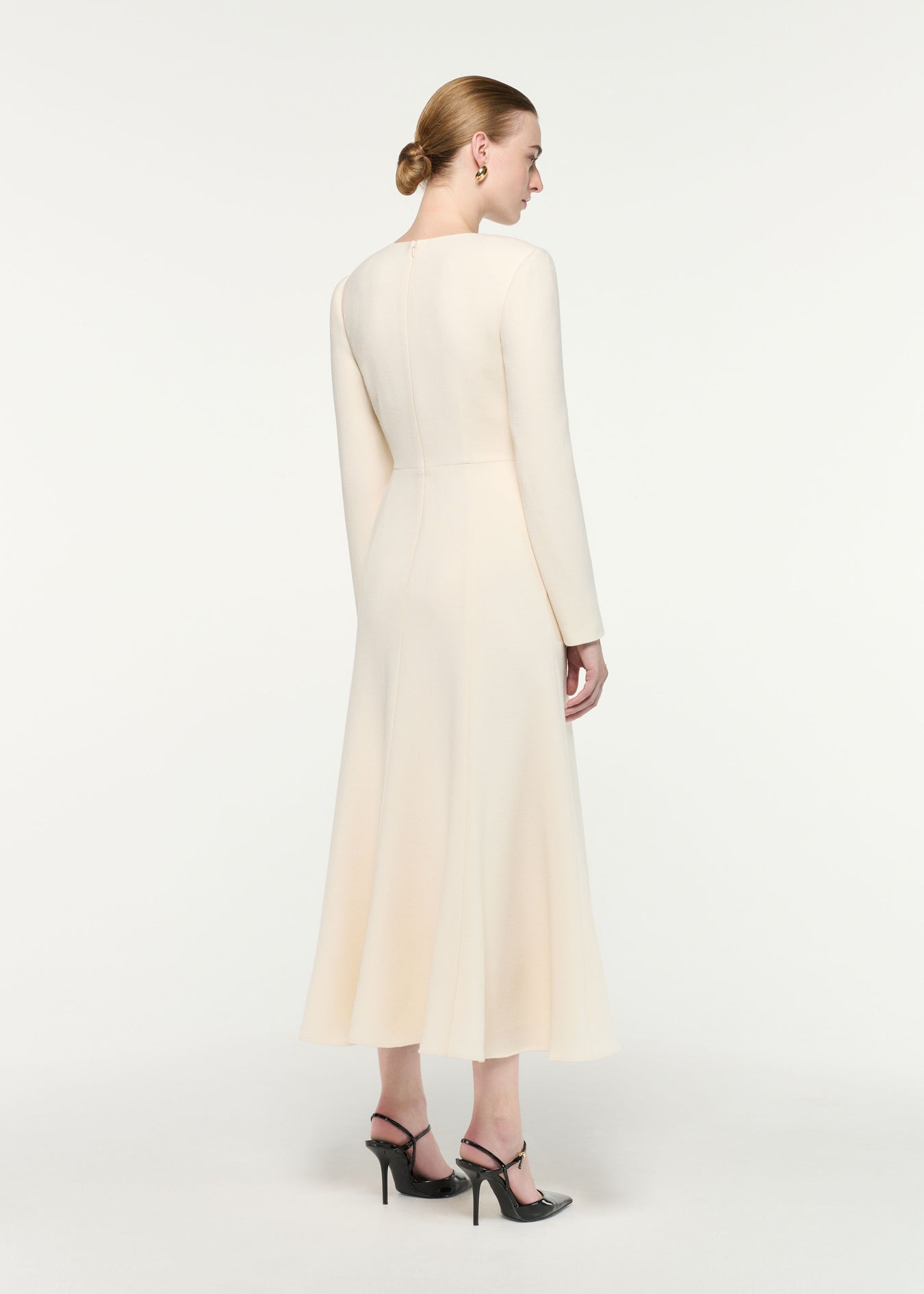 Back view of a model wearing the Asymmetric Bow Neck Wool Crepe Midi Dress