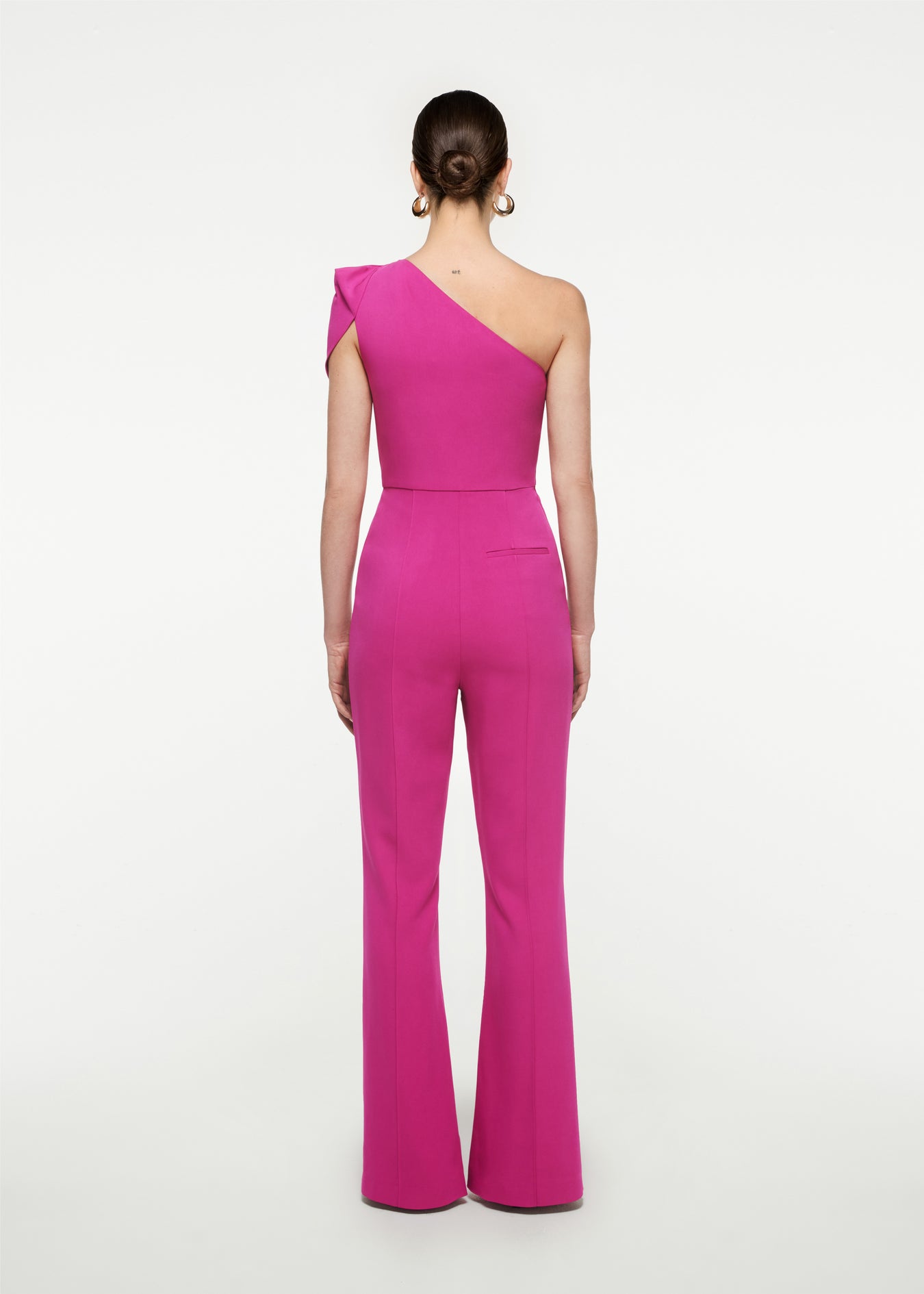 The back of a woman wearing the Asymmetric Stretch Cady Jumpsuit in 