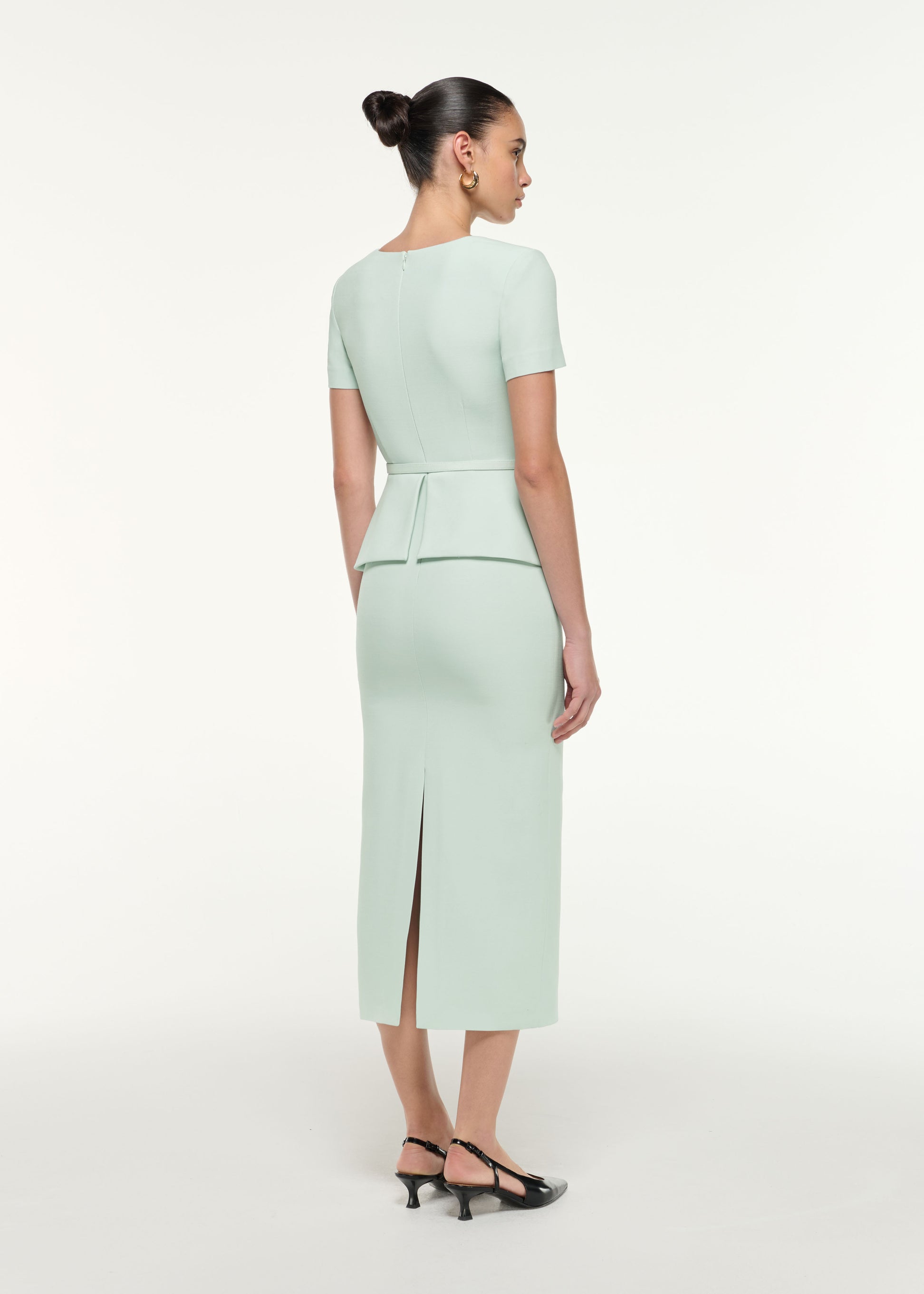 Back view of a model wearing the Peplum Wool Silk Midi Dress in Mint