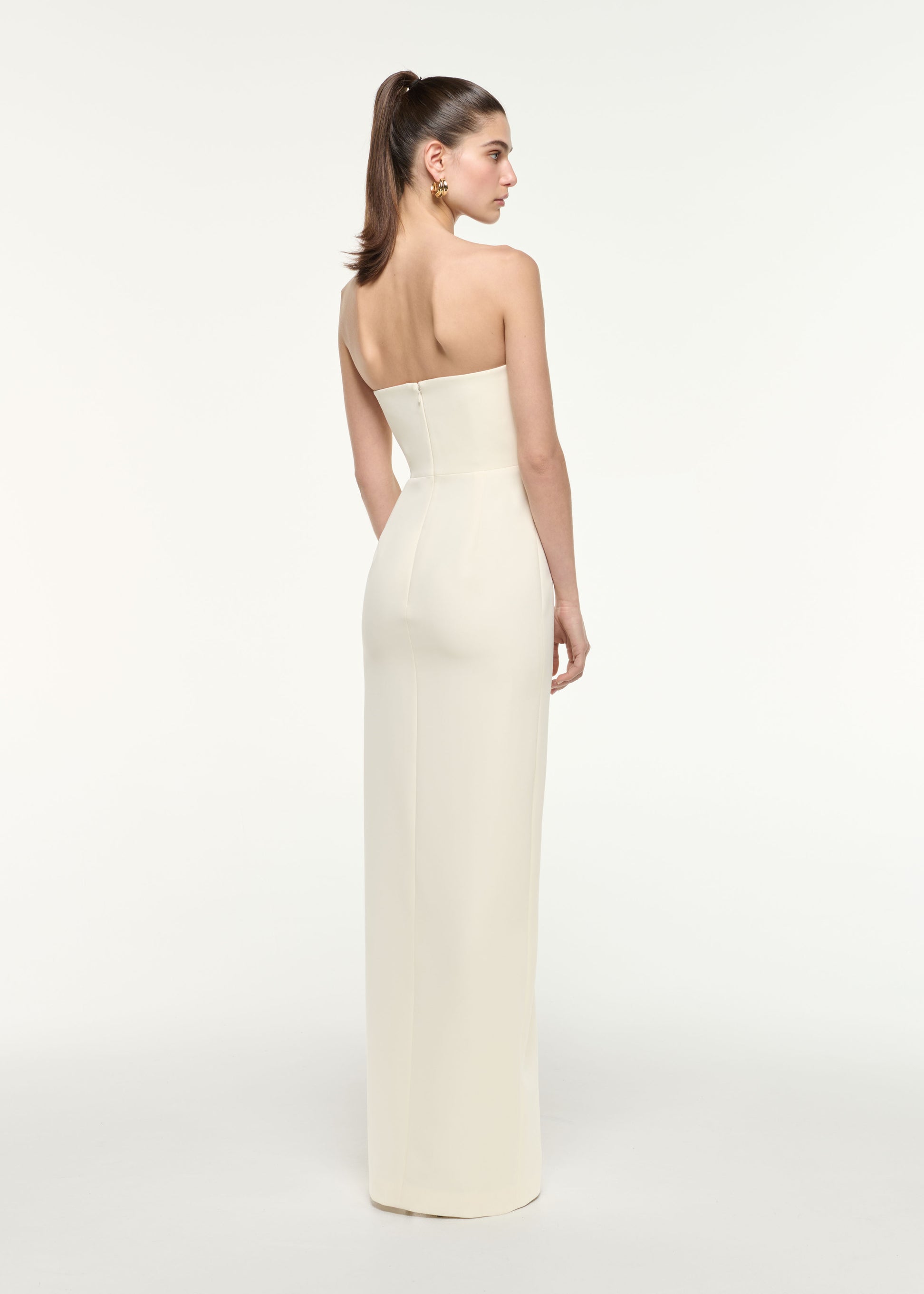 Back view of a model wearing the Diamante Sweetheart Strapless Gown in Cream