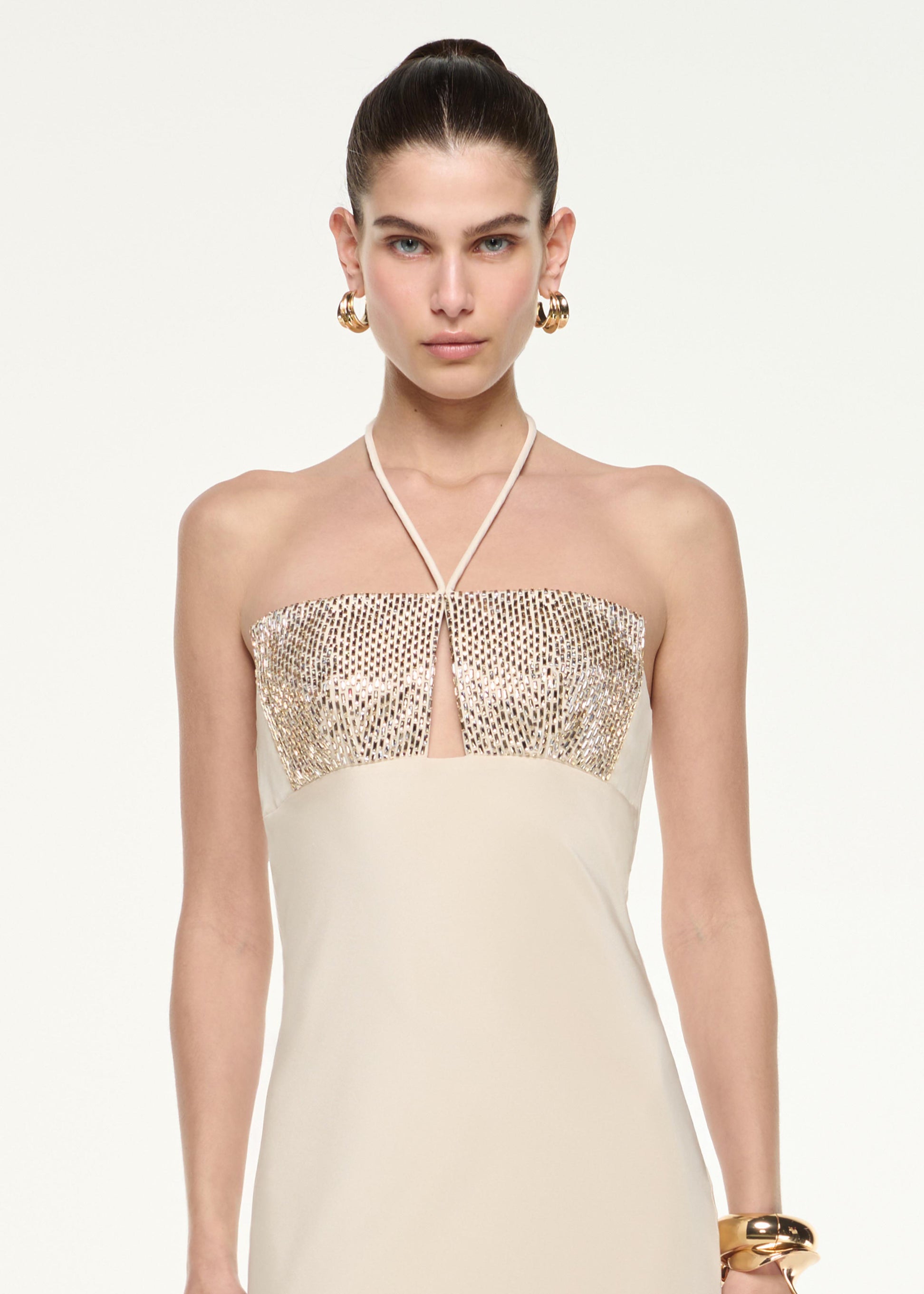 Close up of a model wearing the Diamante Halter Neck Silk Gown in Champagne