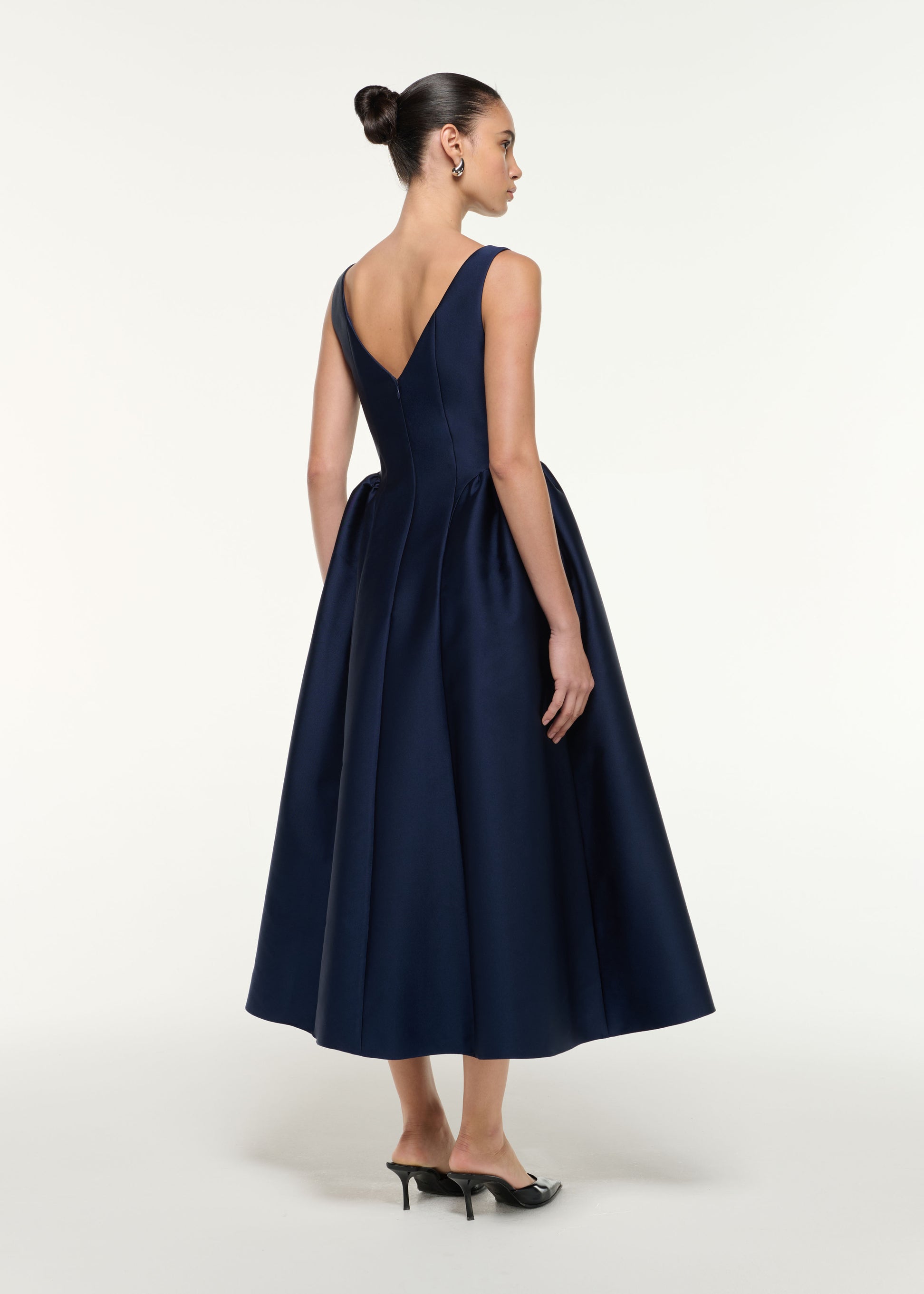 Back view of a model wearing the Taffeta Midi Dress in Navy