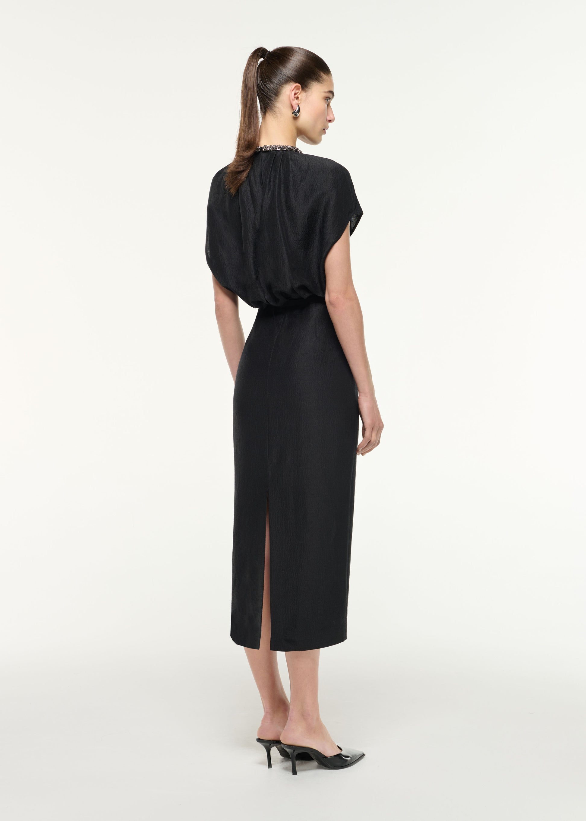 Back view of a model wearing the Silk Jacquard Midi Dress in Black
