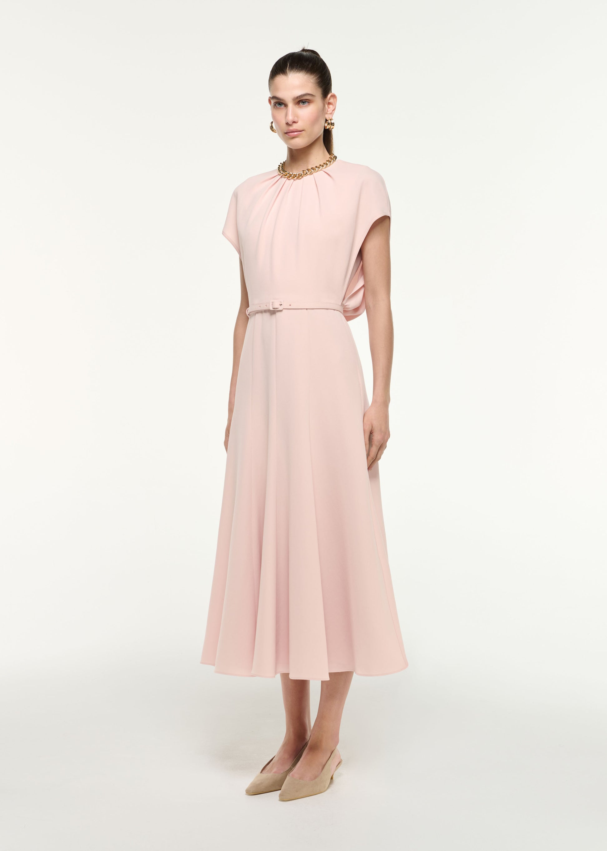 Side view of a model wearing the Belted Cape Midi Dress in Nude