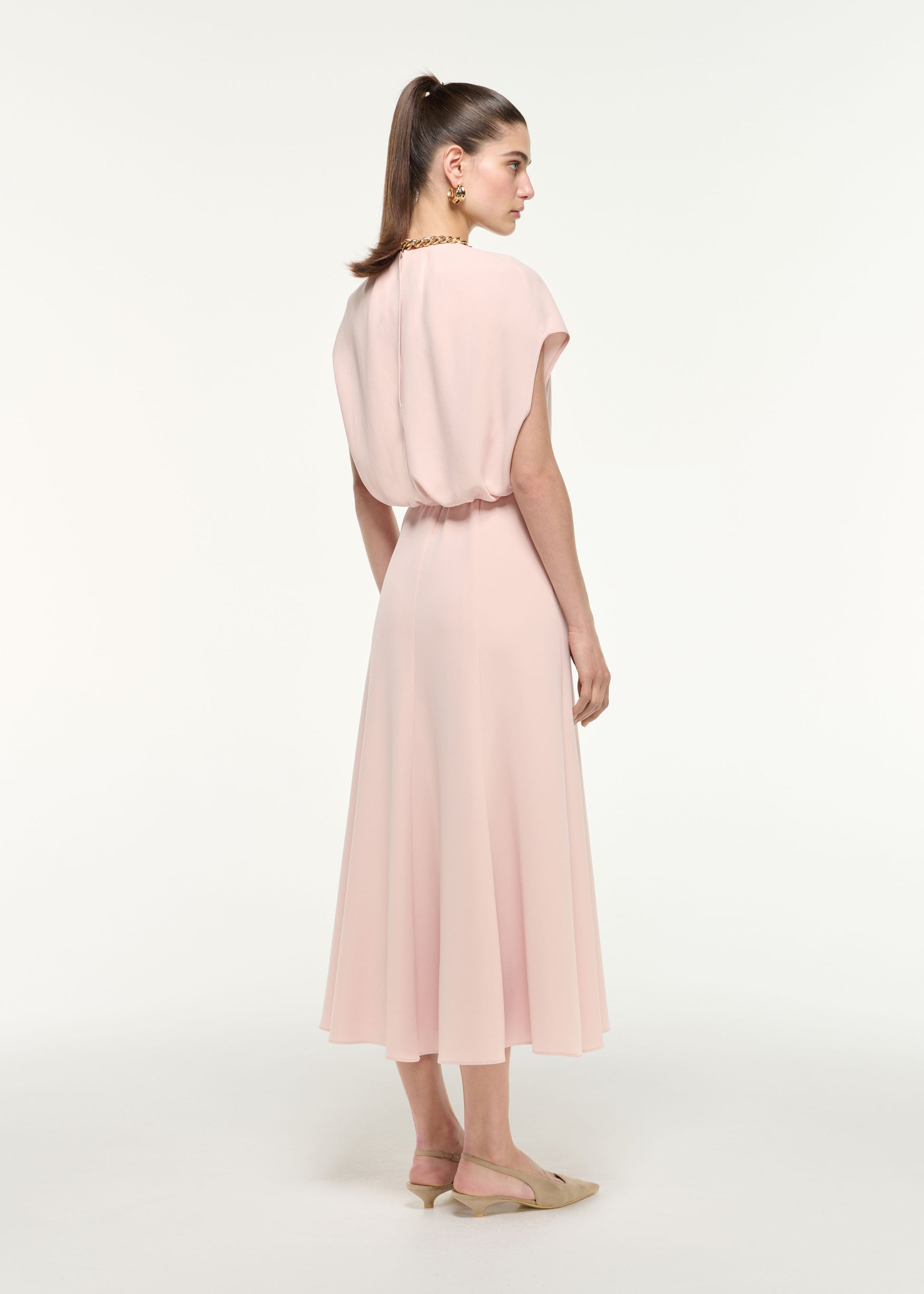 Back view of a model wearing the Belted Cape Midi Dress in Nude