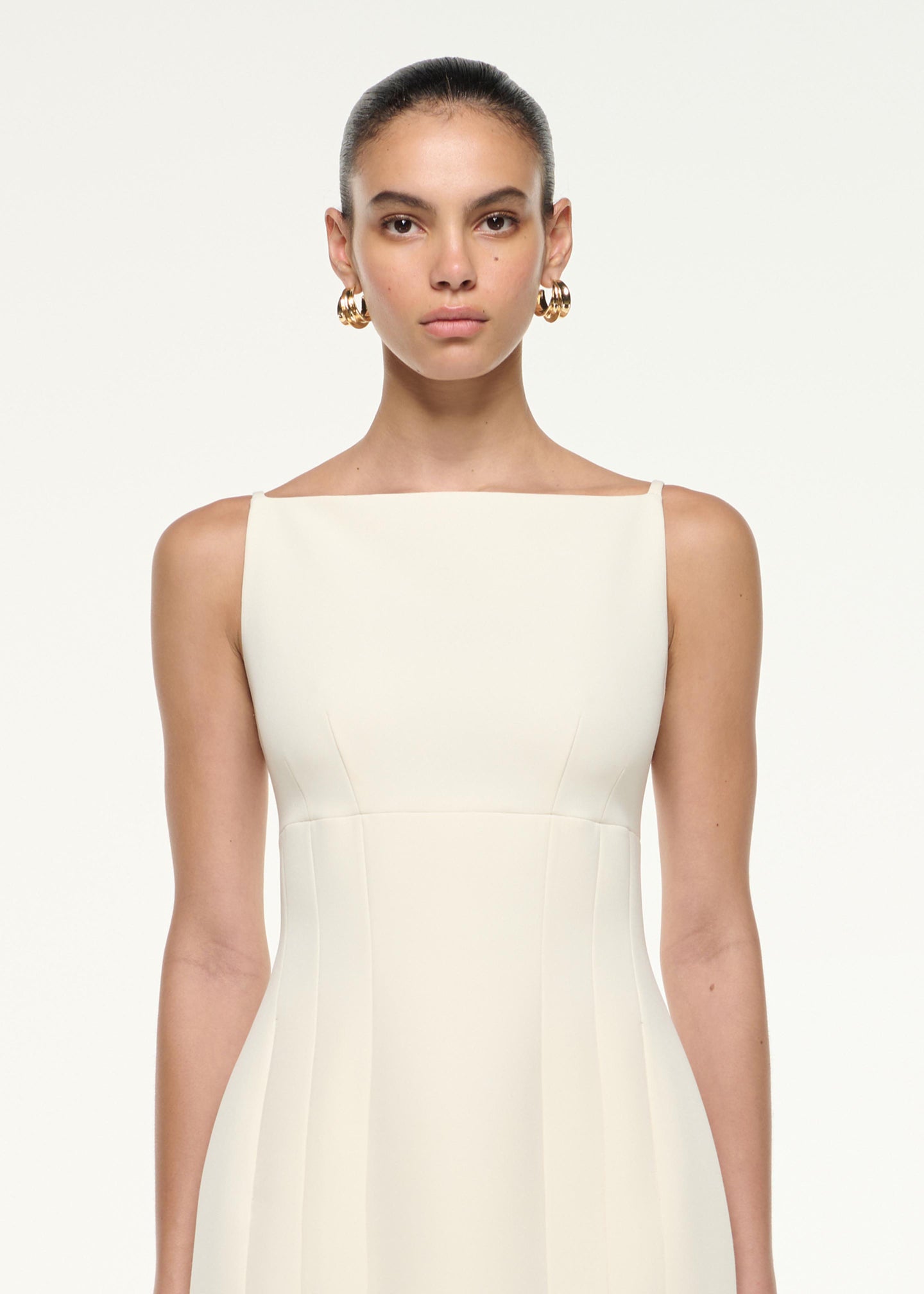 Close up of a model wearing the Light Crepe Strap Mini Dress in Cream