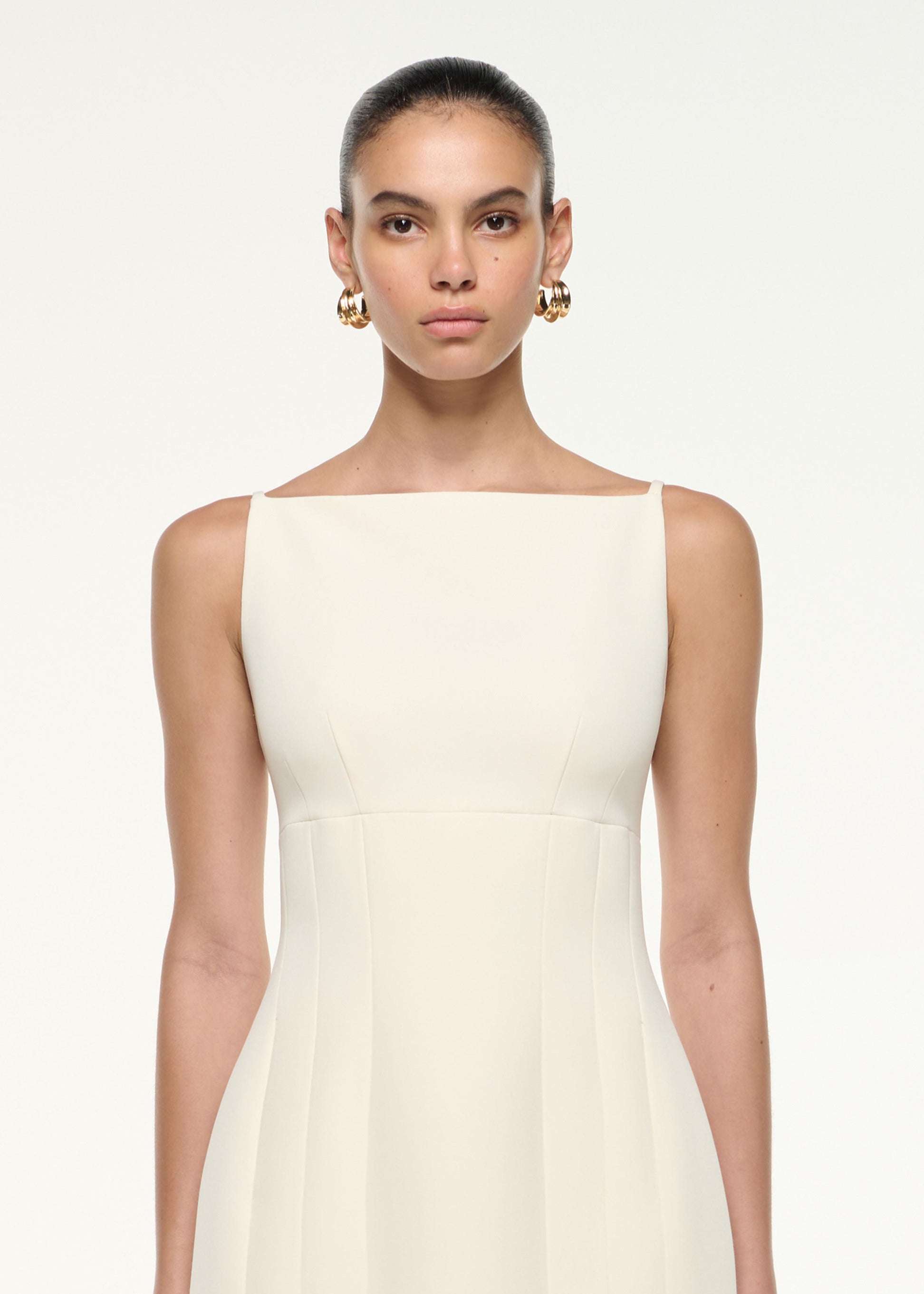 Close up of a model wearing the Light Crepe Strap Mini Dress in Cream