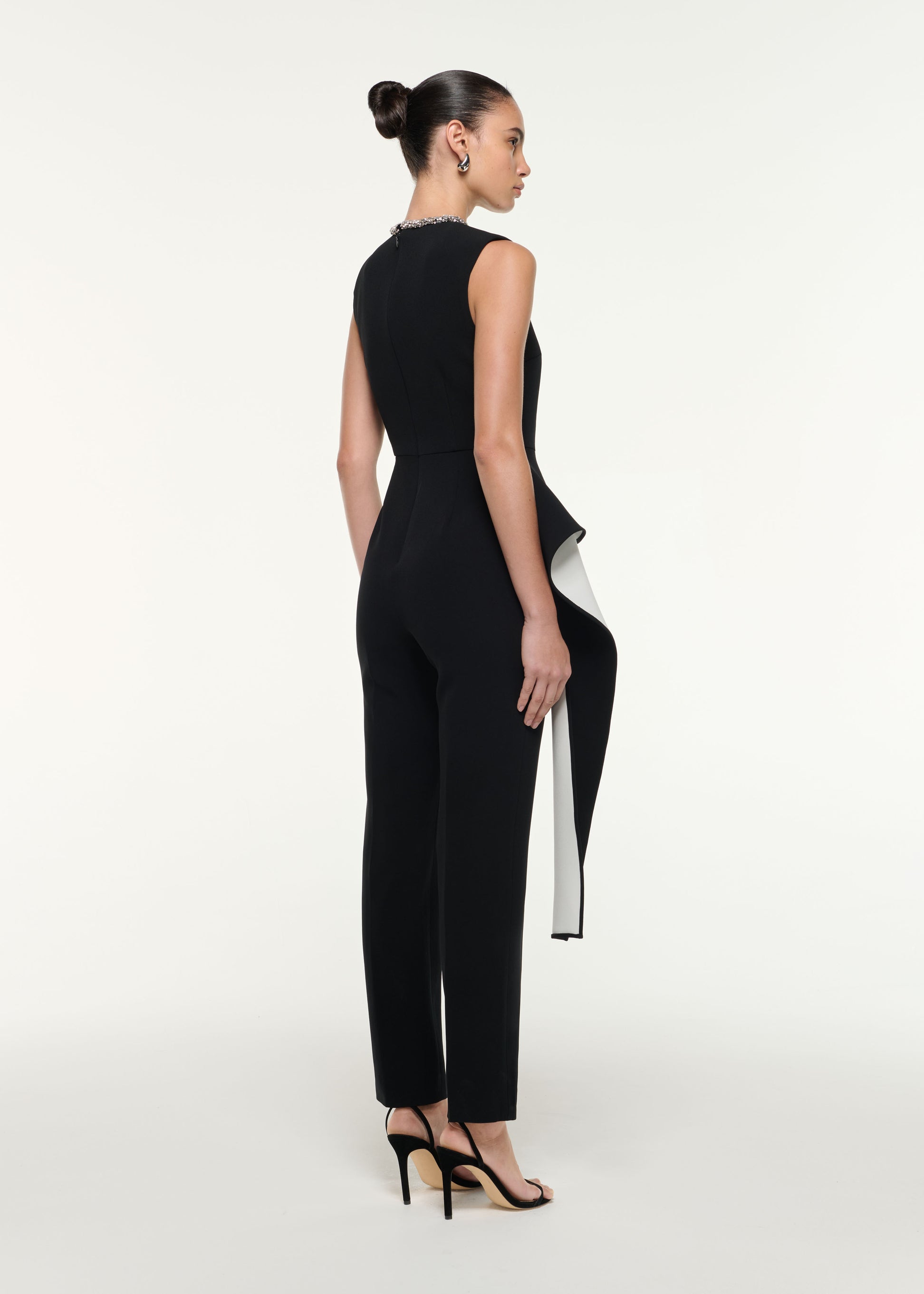 Back view of a model wearing the Waist Drape Jumpsuit in Monochrome