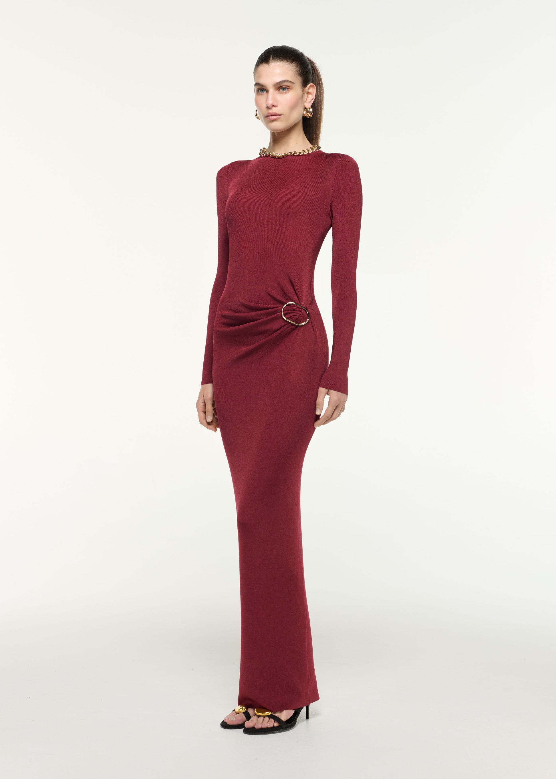 Side view of a model wearing the Gathered Buckle Knit Maxi Dress in Dark Red