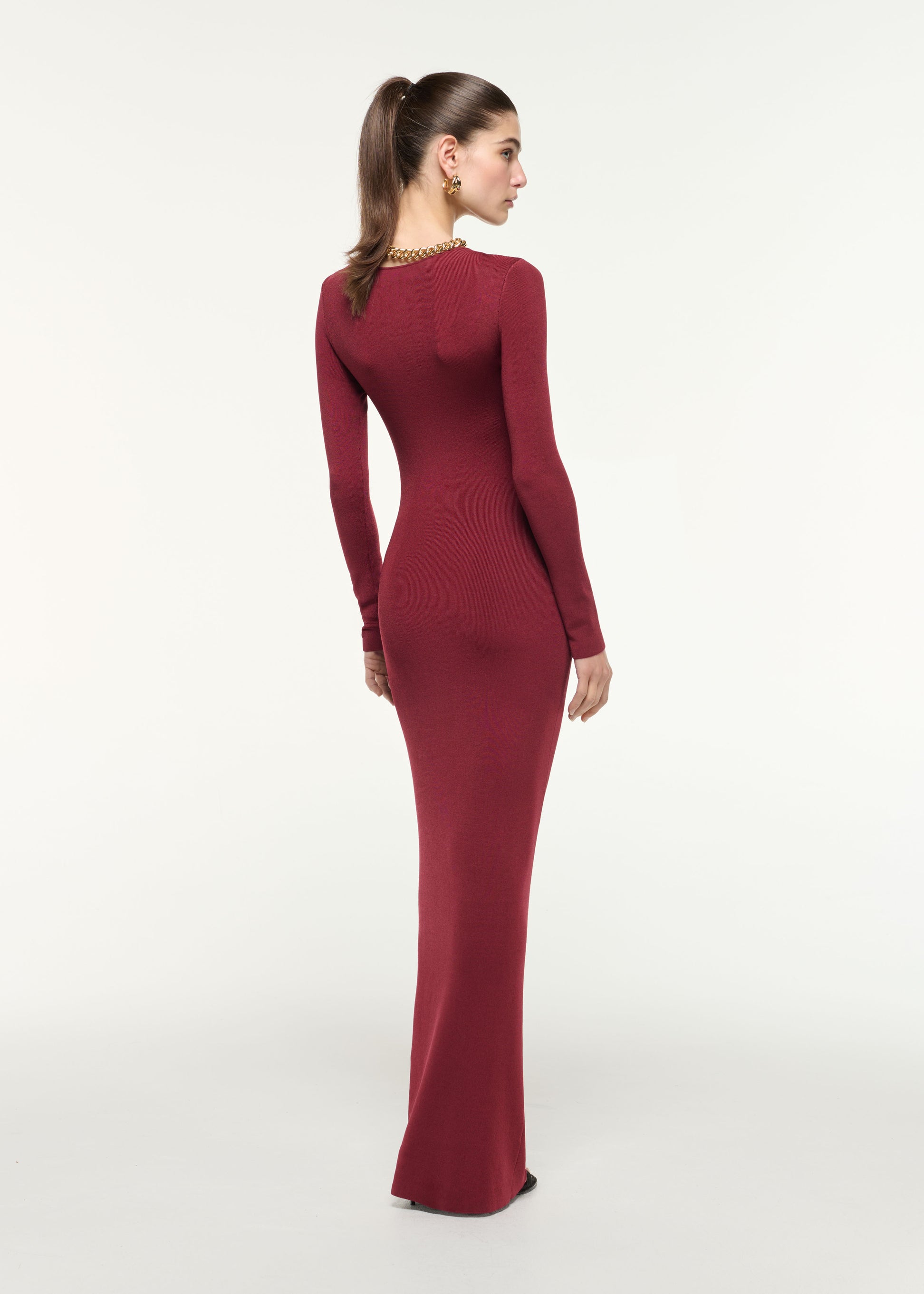 Back view of a model wearing the Gathered Buckle Knit Maxi Dress in Dark Red