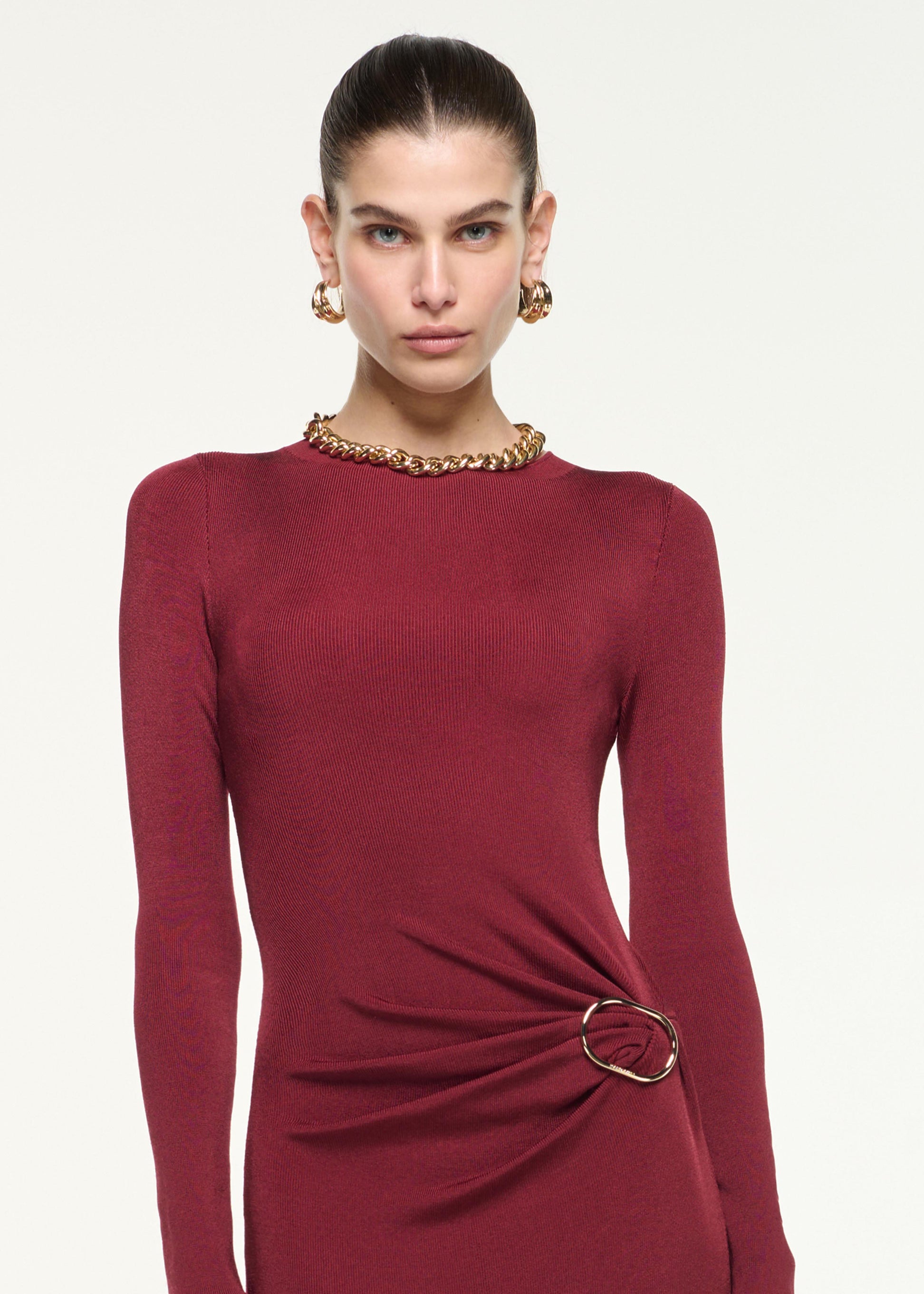 Close up of a model wearing the Gathered Buckle Knit Maxi Dress in Dark Red