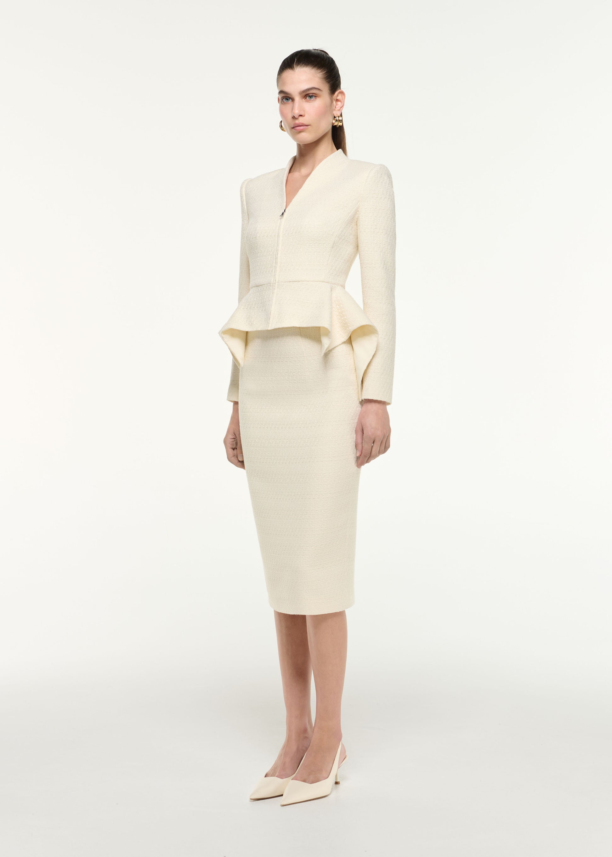 Side view of a model wearing the Boucle Peplum Jacket in Cream