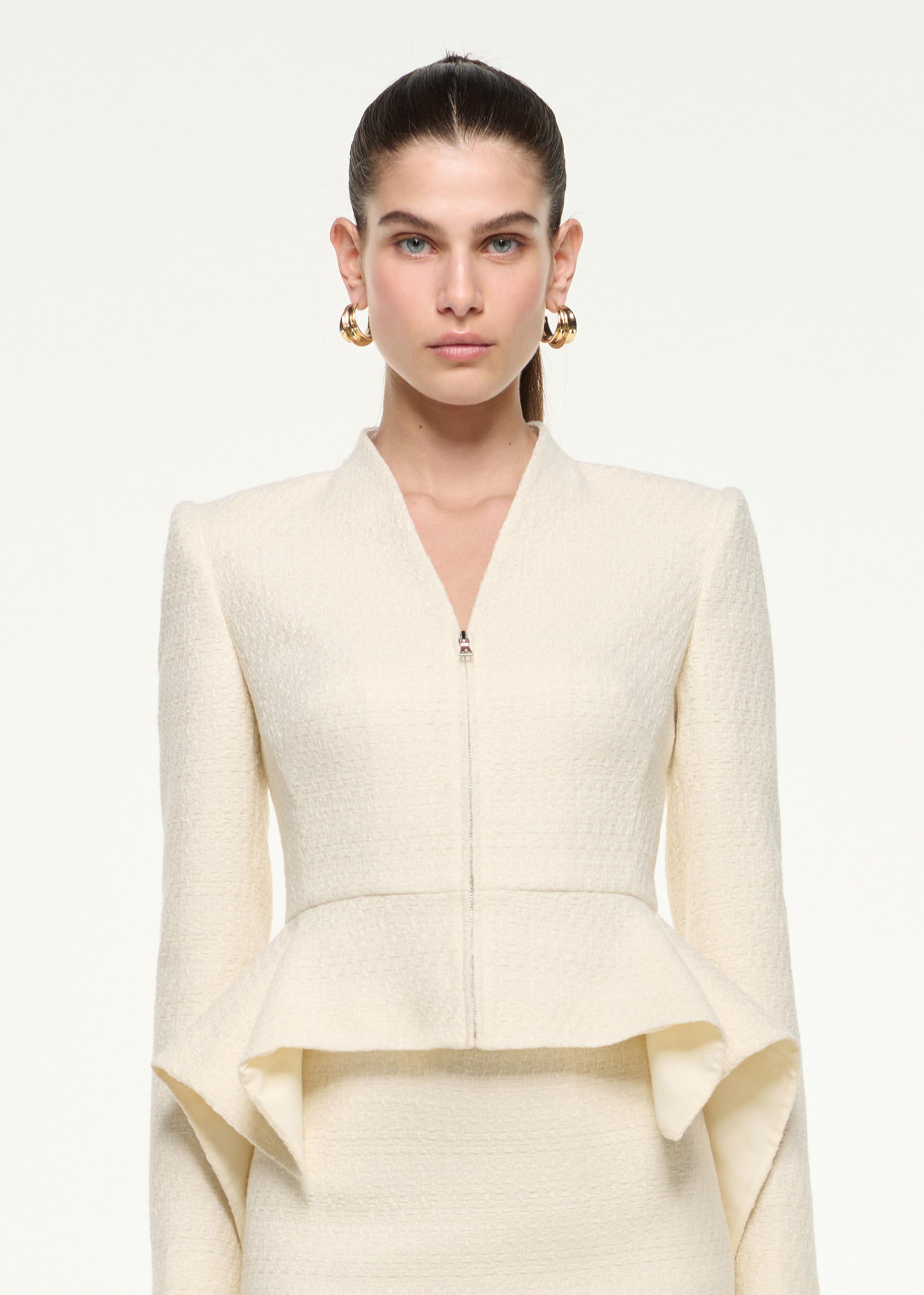 Close up of a model wearing the Boucle Peplum Jacket in Cream
