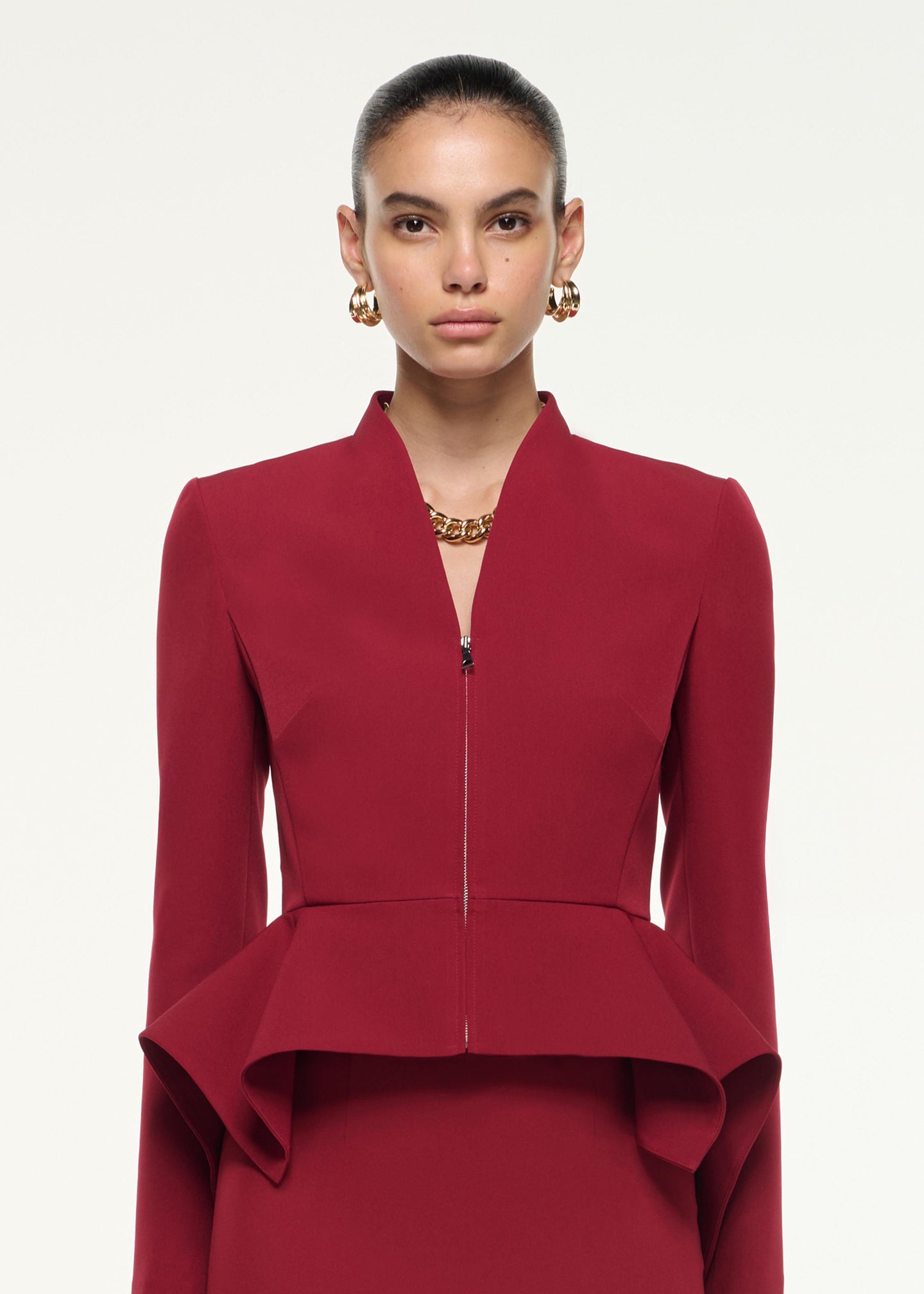 Close up of a model wearing the Peplum Jacket in Dark Red