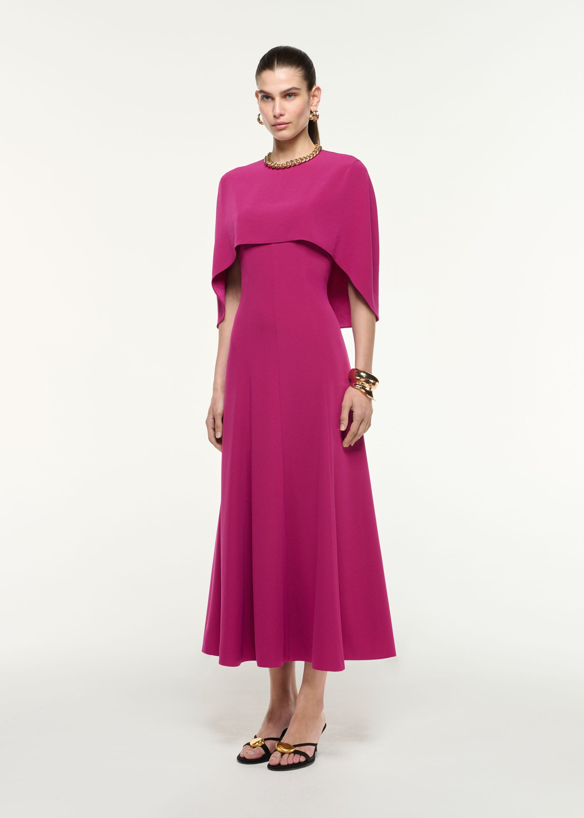 Side view of a model wearing the Satin Crepe Cape Midi Dress in Dark Pink