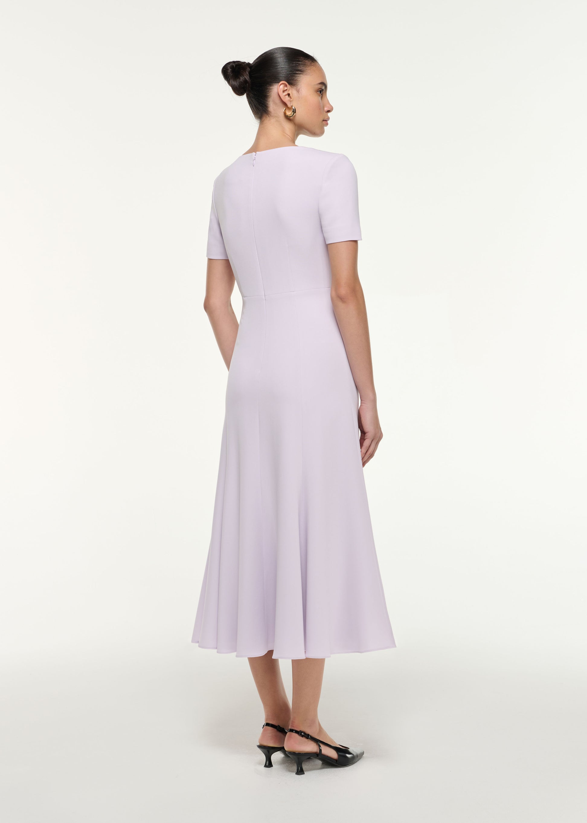 Back view of a model wearing the Shoulder Drape Midi Dress in Lilac