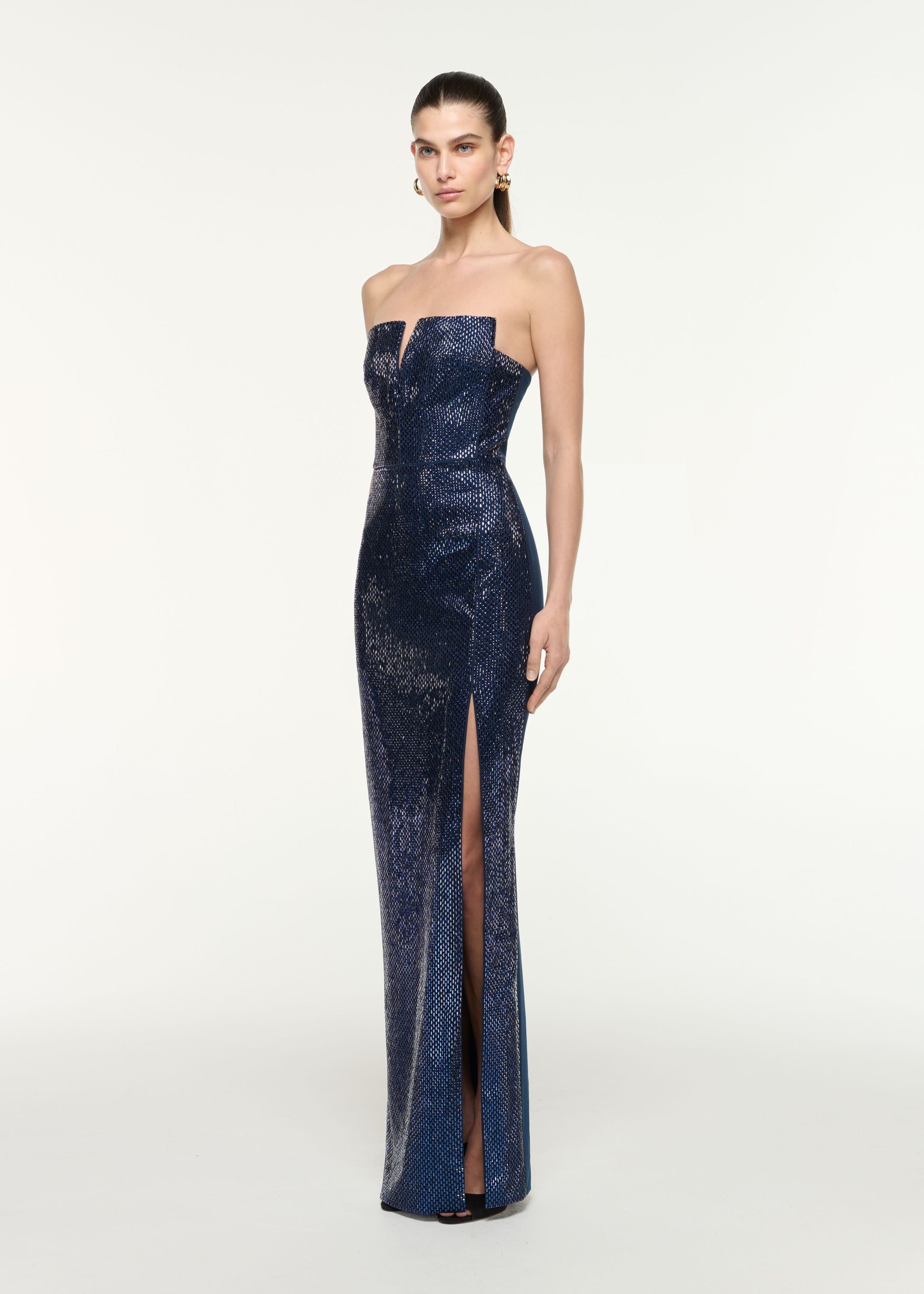 Side view of a model wearing the Strapless All Over Diamante Gown in Navy