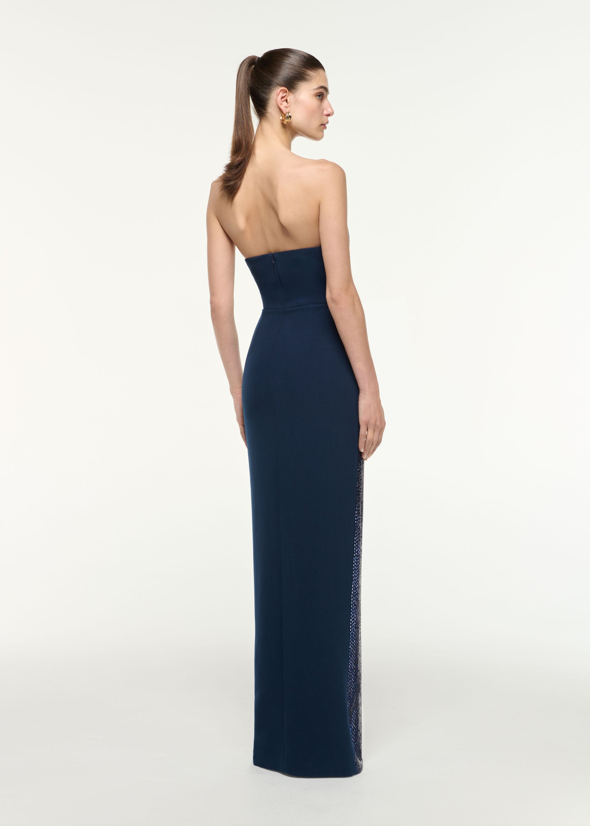 Back view of a model wearing the Strapless All Over Diamante Gown in Navy