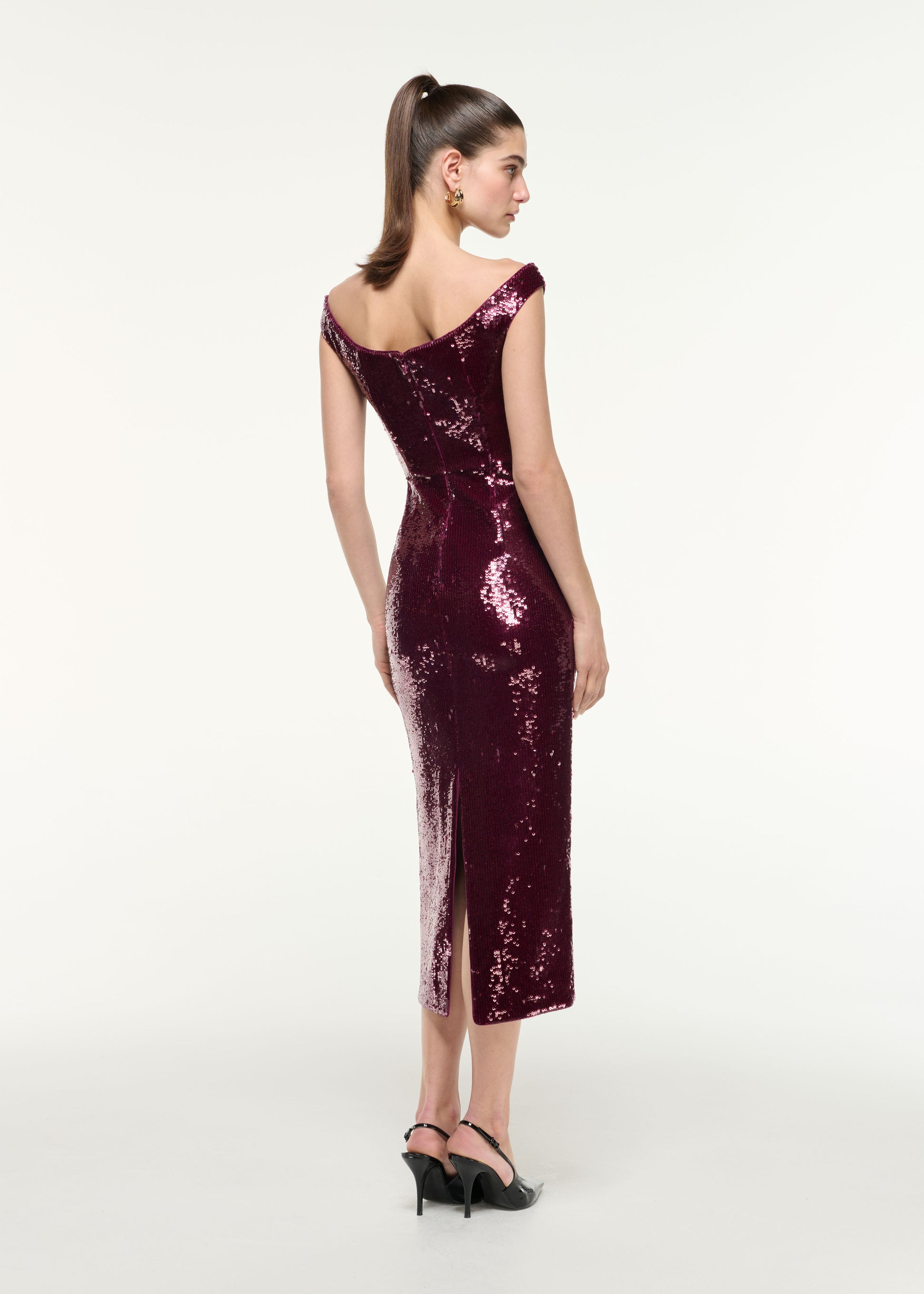 Back view of a model wearing the Off Shoulder Sequin Midi Dress in Dark Pink