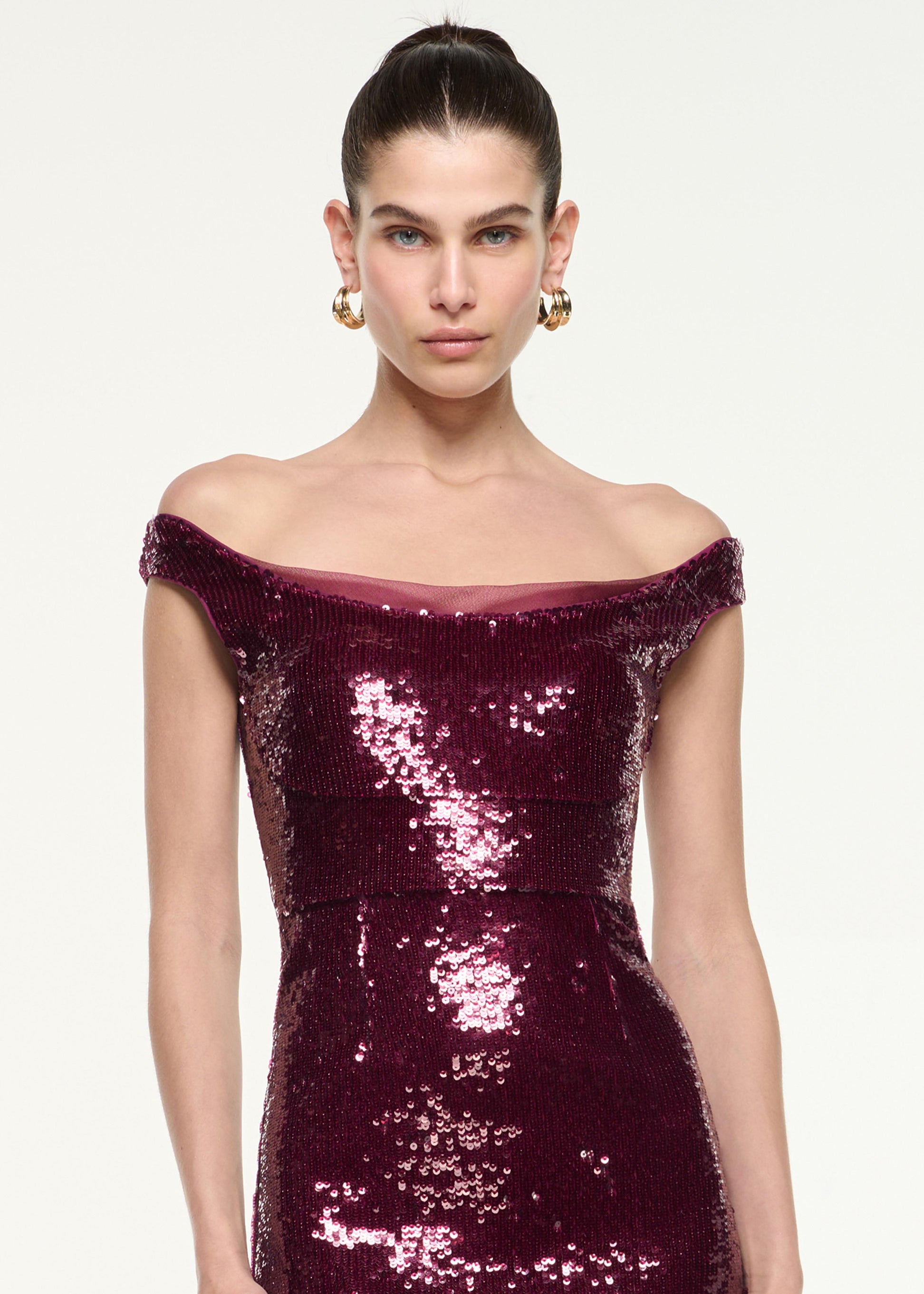 Close up of a model wearing the Off Shoulder Sequin Midi Dress in Dark Pink