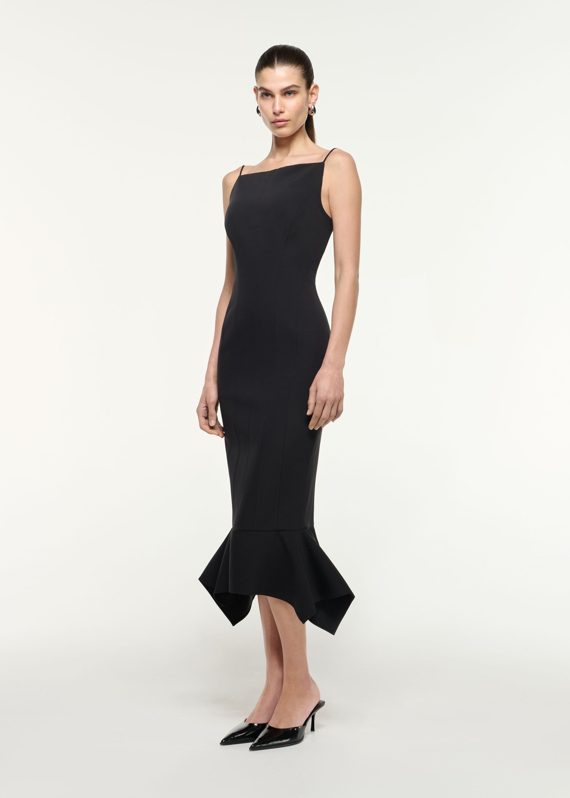 Side view of a model wearing the Fishtail Hem Midi Dress in Black