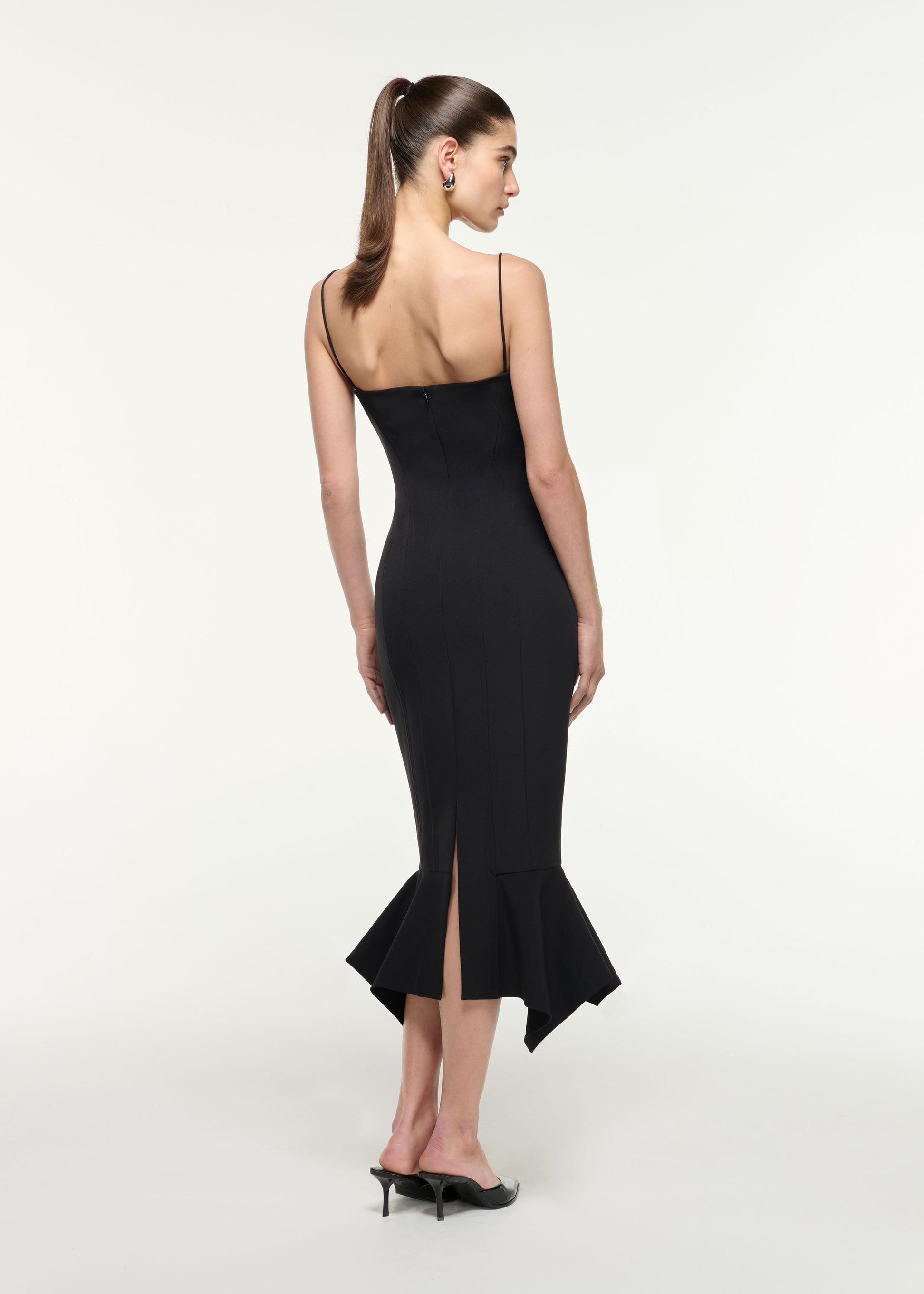 Back view of a model wearing the Fishtail Hem Midi Dress in Black