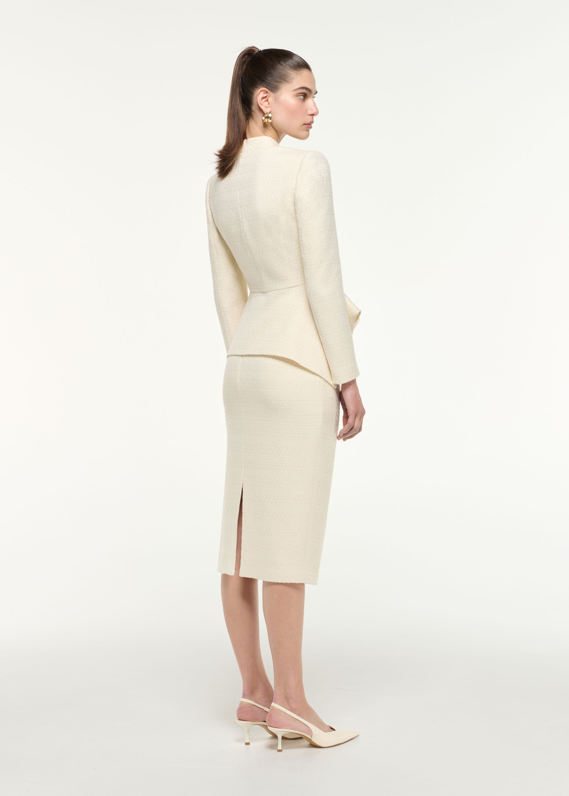 Back view of a model wearing the Boucle Midi Skirt in Cream