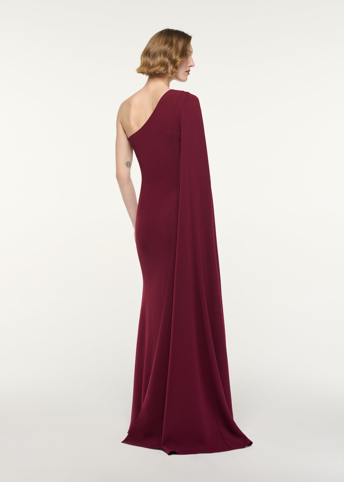 Back view of a model wearing the Diamante Panel One Shoulder Cape Gown