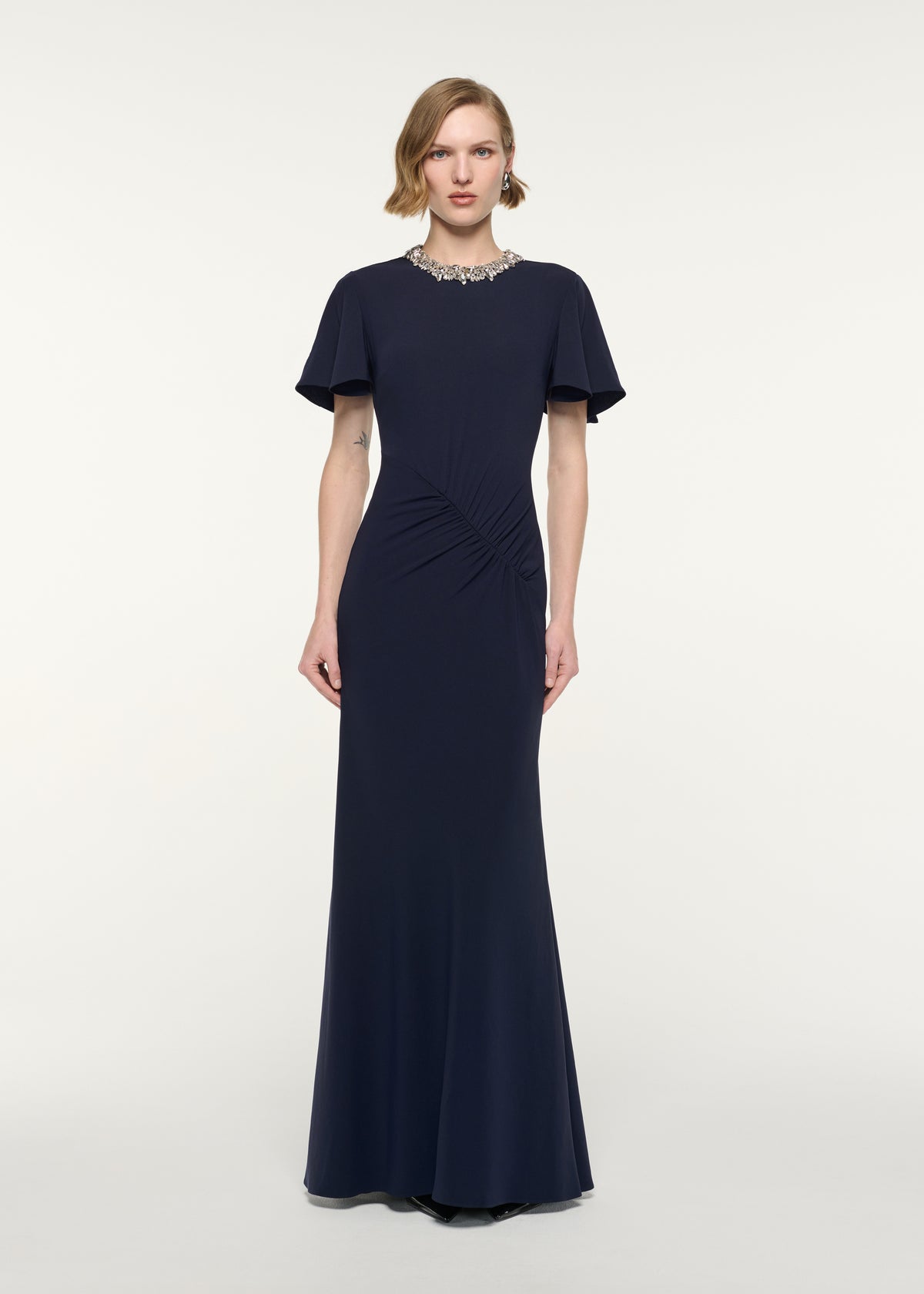 Front view of a model wearing the Crystal Neckline Draped Sleeve Gown
