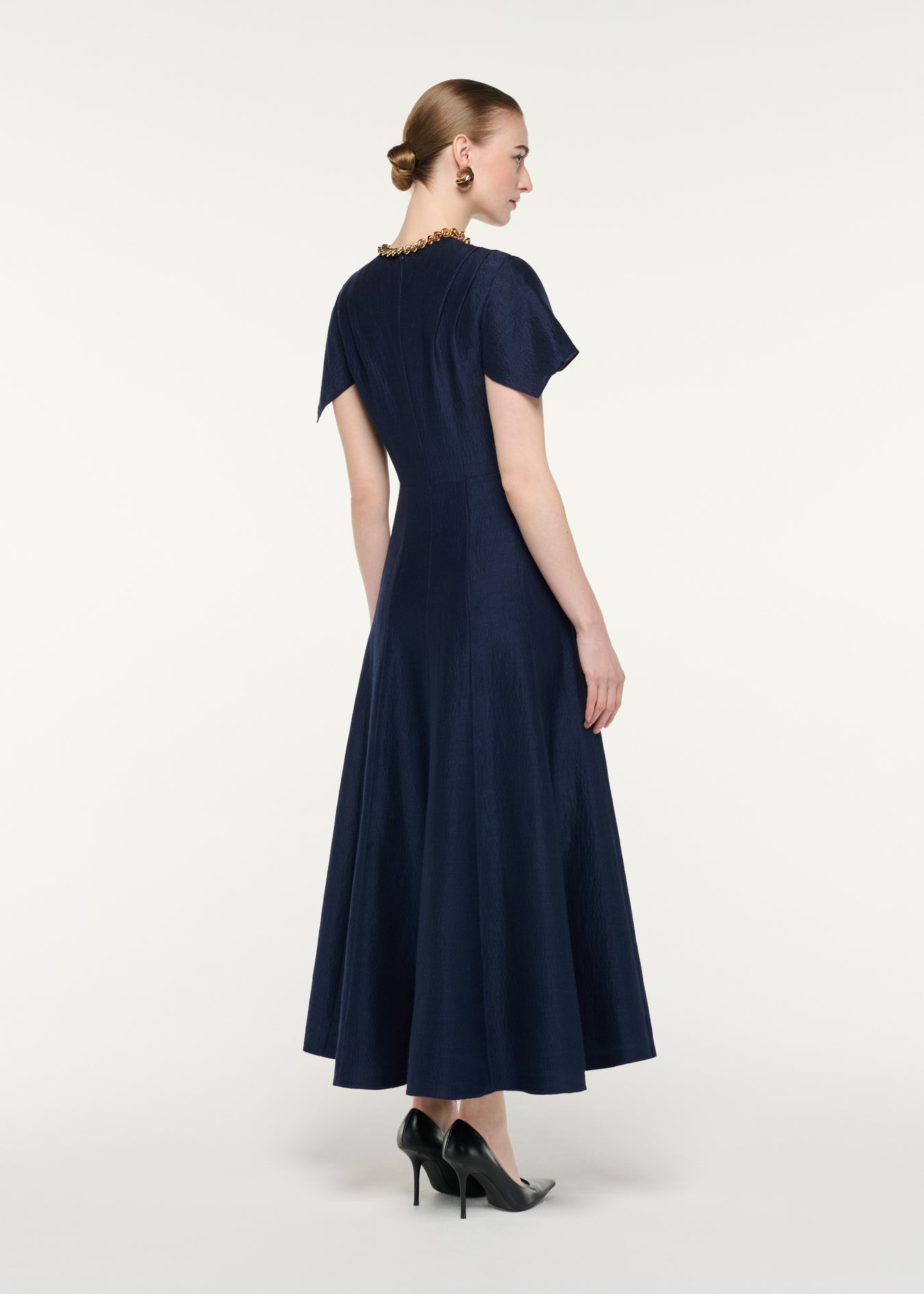 Back view of a model wearing the Draped Waist Midi Dress
